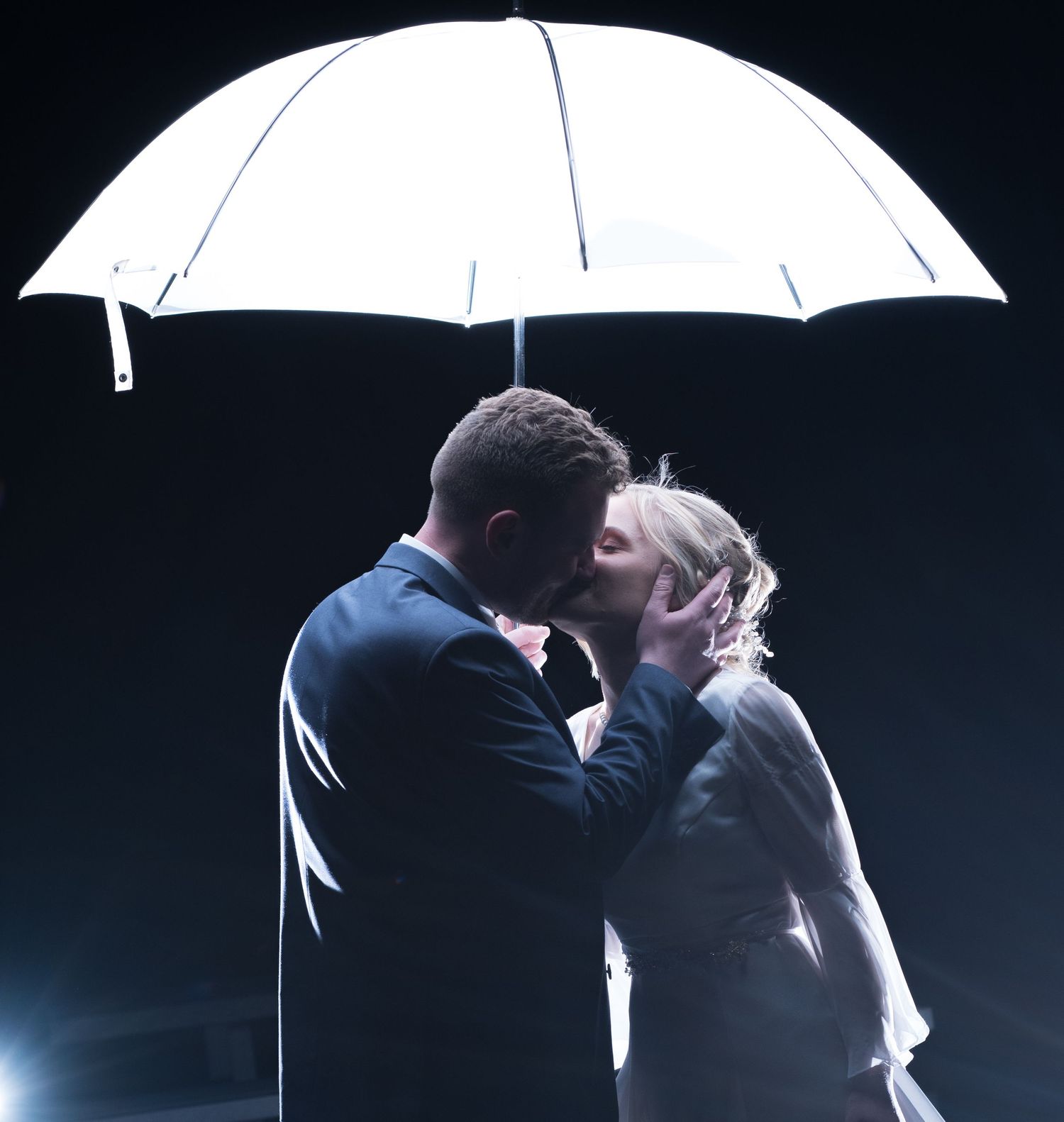 Romantic nighttime umbrella portrait with dramatic backlighting.