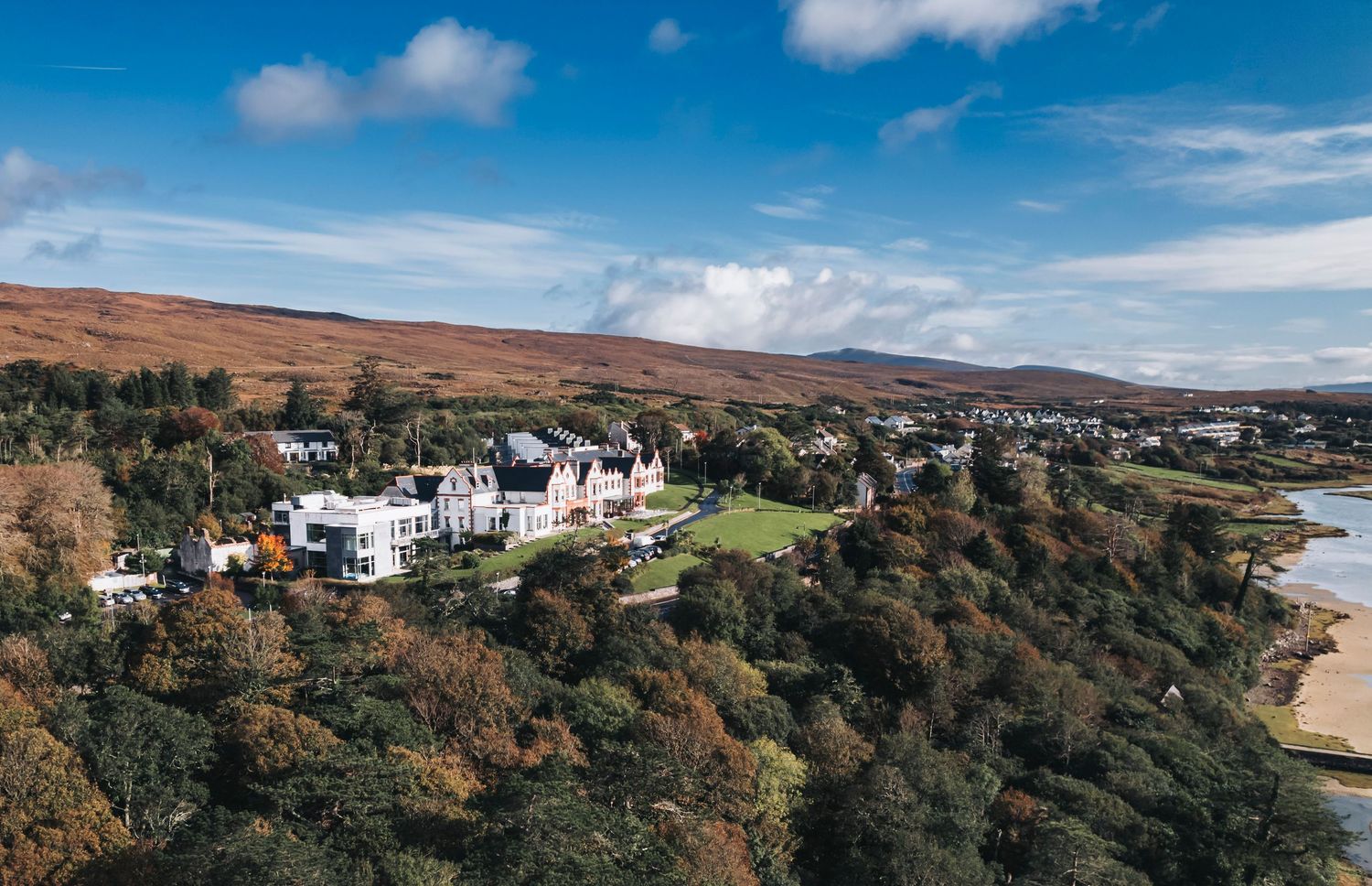 Panoramic coastal landscape with buildings perched along dramatic clifftop terrain.
