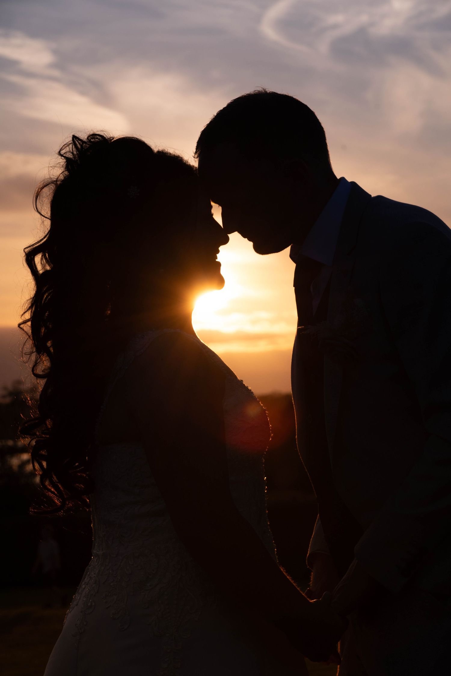 Romantic silhouette of a couple sharing an intimate moment at sunset.