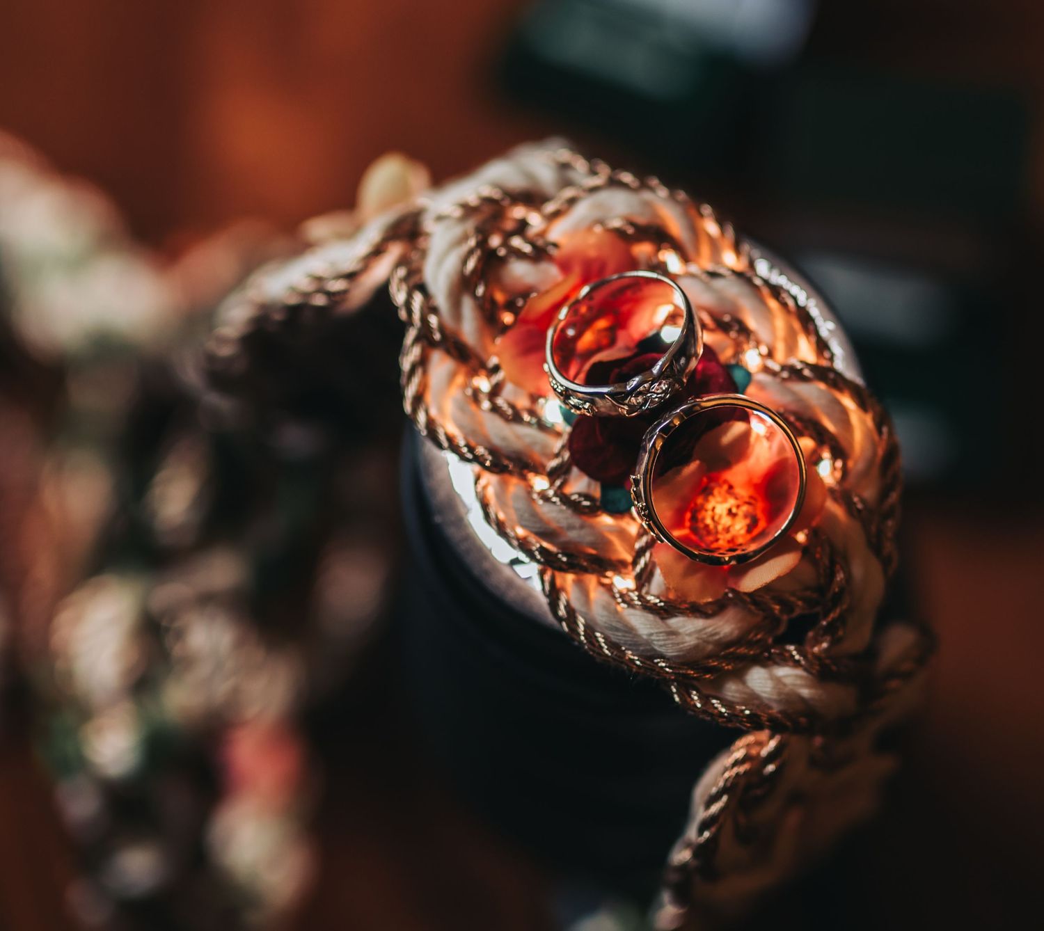 Two ornate amber and gold wedding rings resting on a decorative golden jewelry holder.