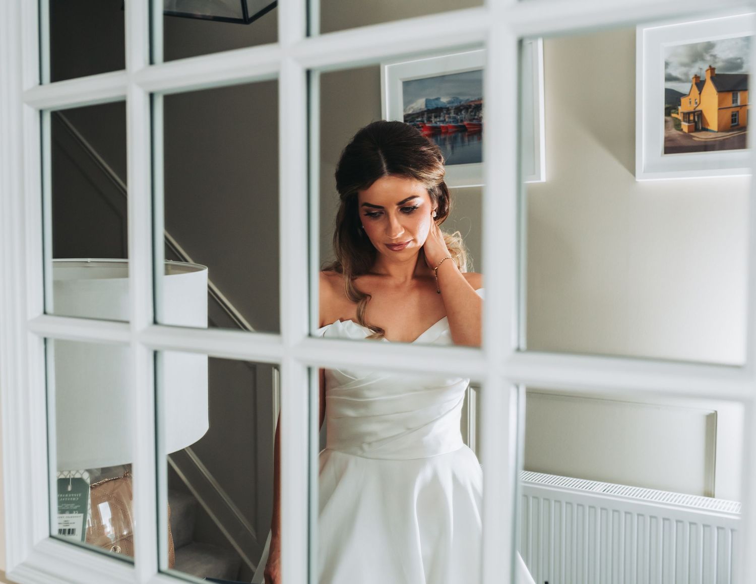 Artistic window frame composition showing a wedding dress through glass panes.