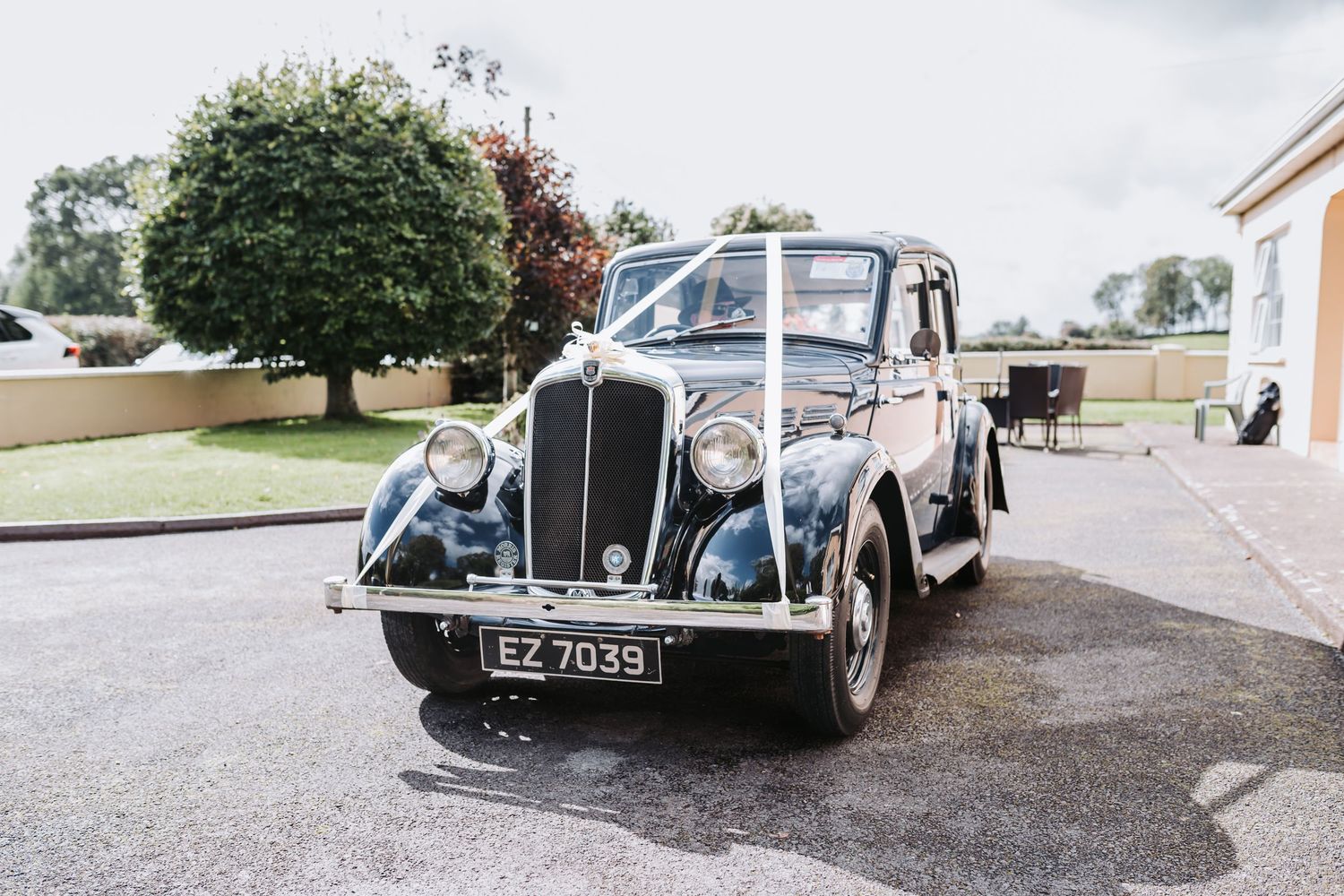 Classic vintage black wedding car with license plate EZ 7039 parked outside venue.