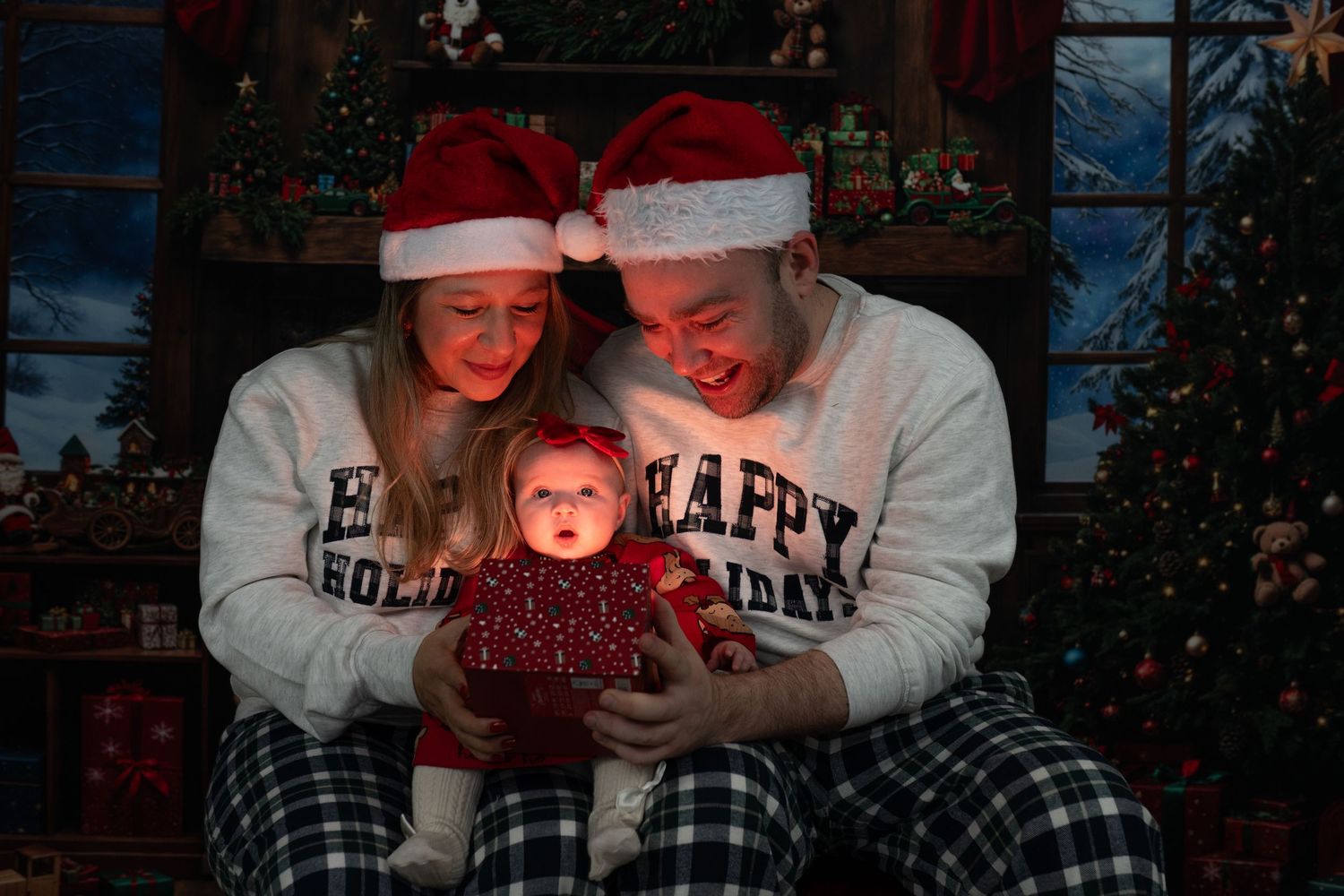 A couple in cozy winter attire looks at a glowing phone screen together during the holiday season.