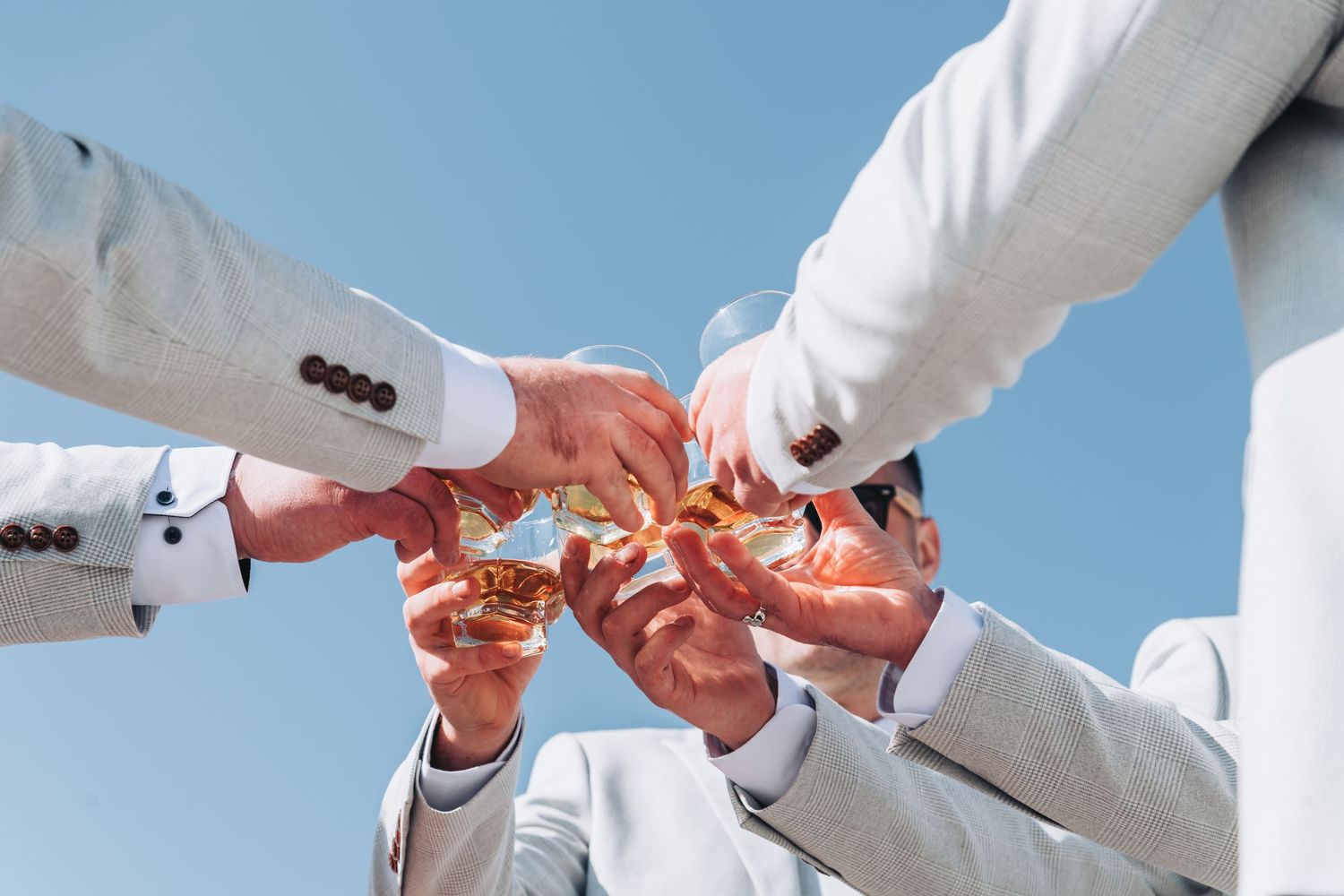 Close-up sequence of hands adjusting formal white suit details.