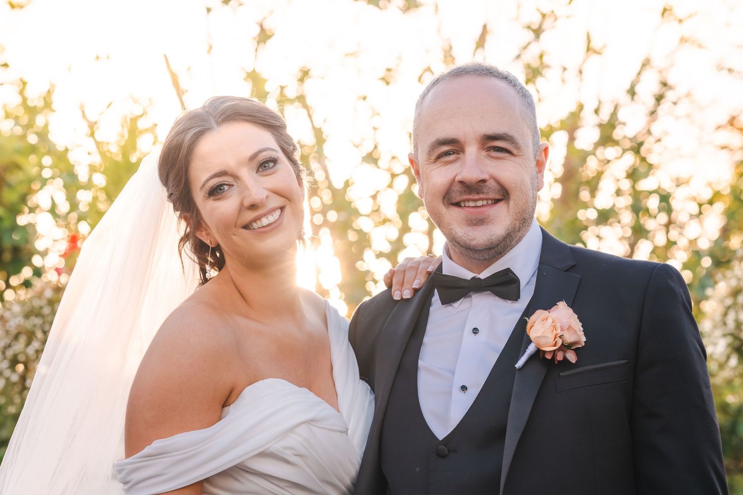 A bride and groom share romantic moments at sunset during their outdoor wedding celebration.