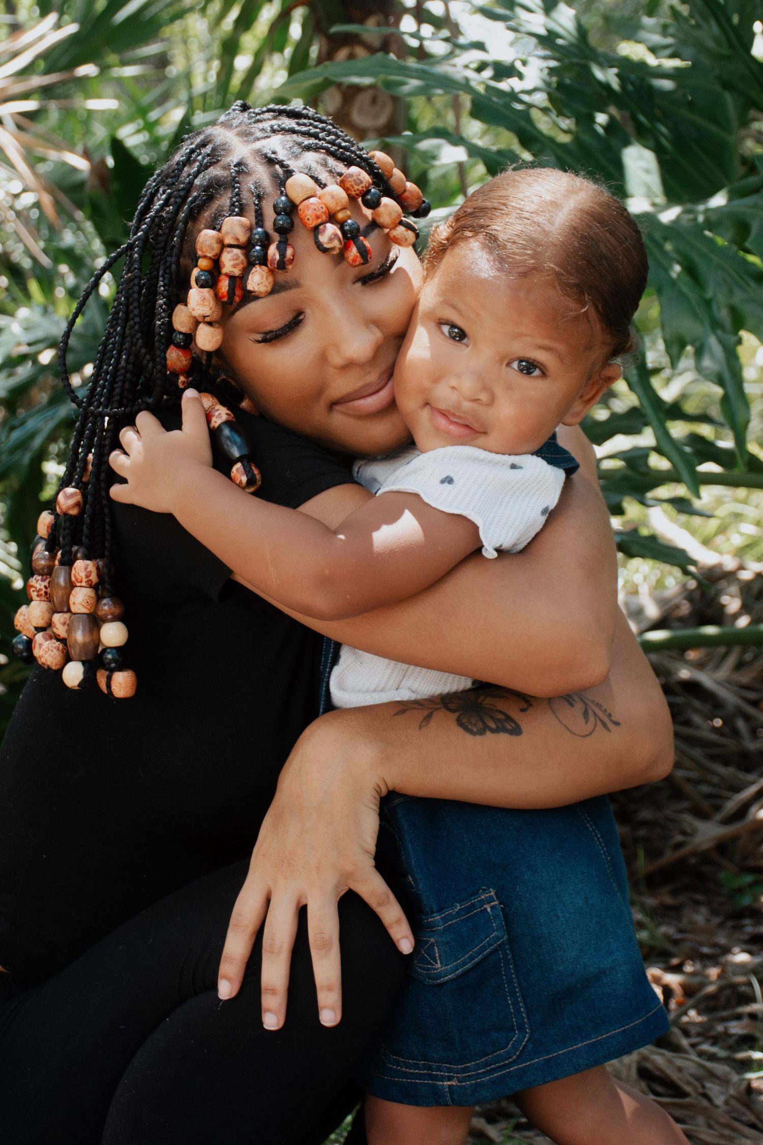 A tender embrace between parent and child in a lush garden setting shows warmth and connection in natural lighting.