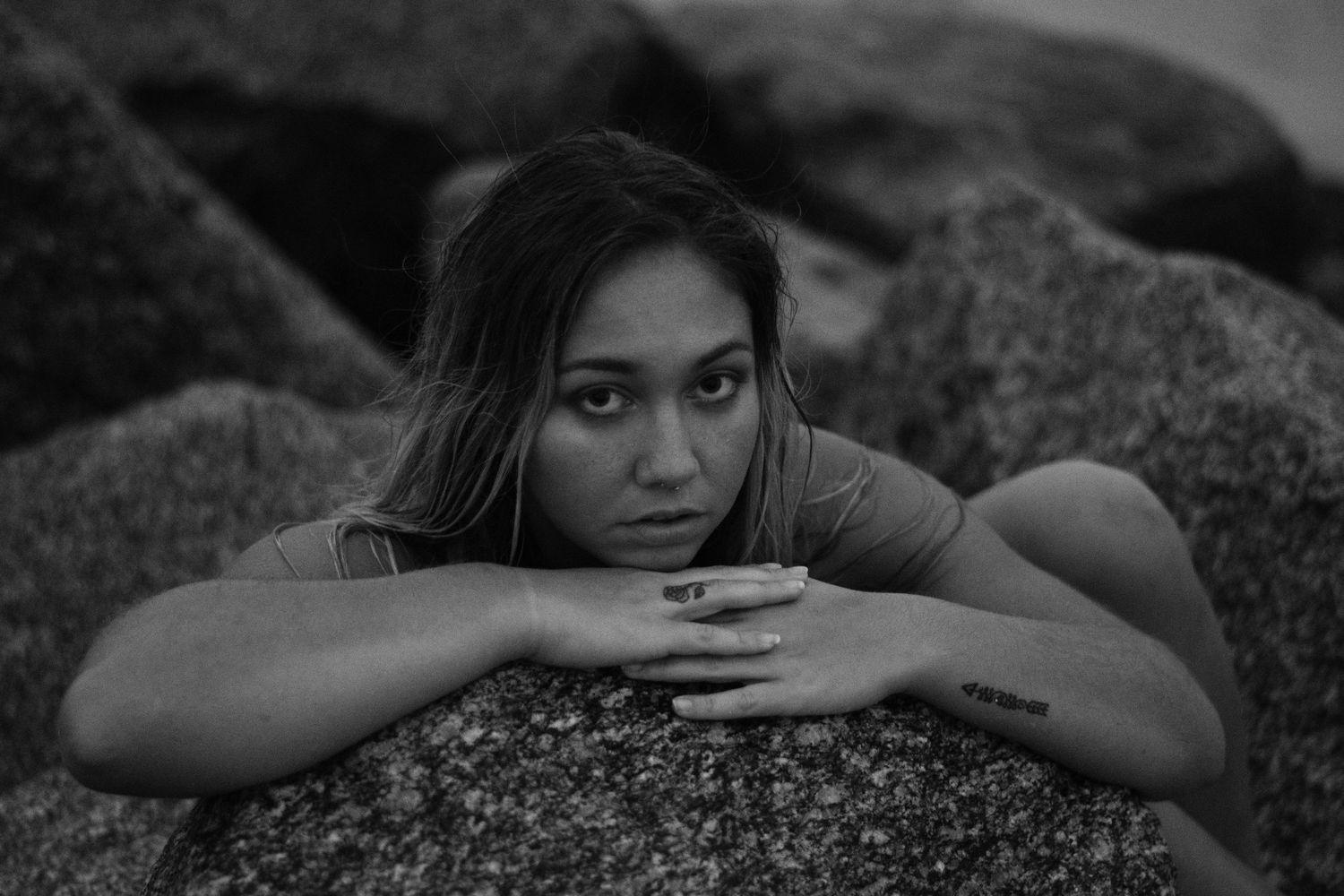 Moody black and white portrait on rocky beach landscape.