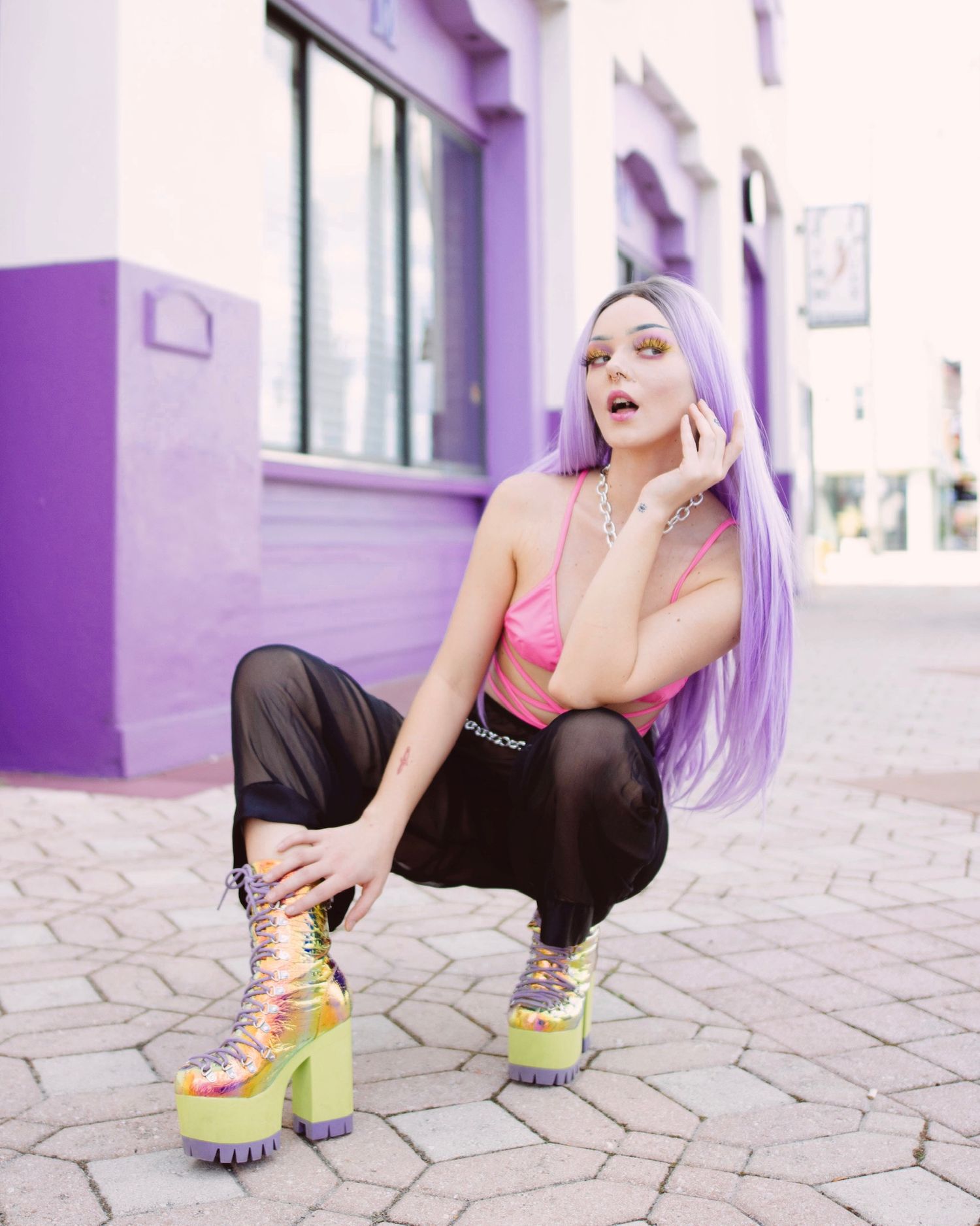 Urban fashion shoot against purple walls featuring colorful platform sneakers and casual streetwear.