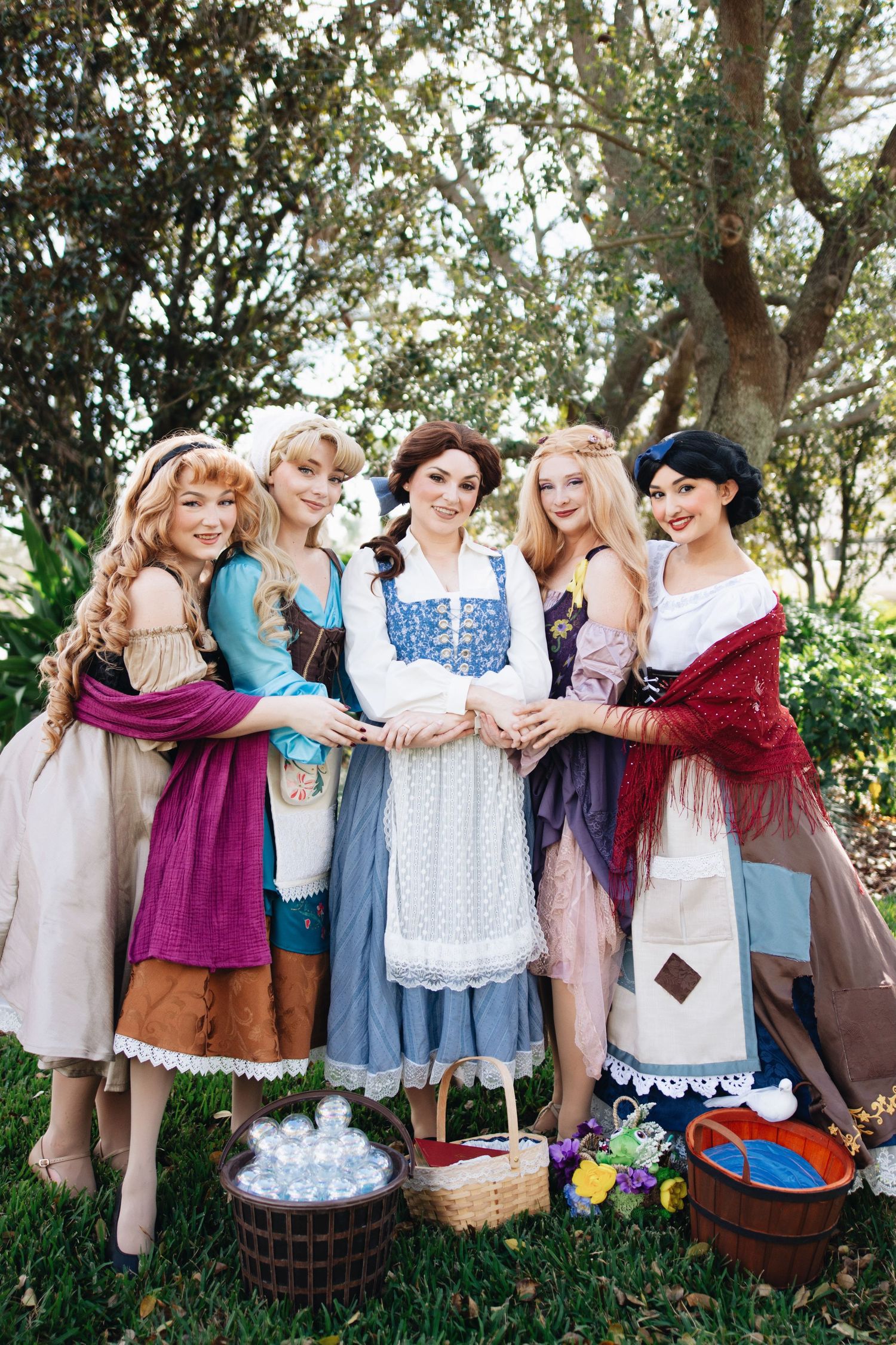Women dressed in vintage-style clothing and aprons gather for a themed group photo.