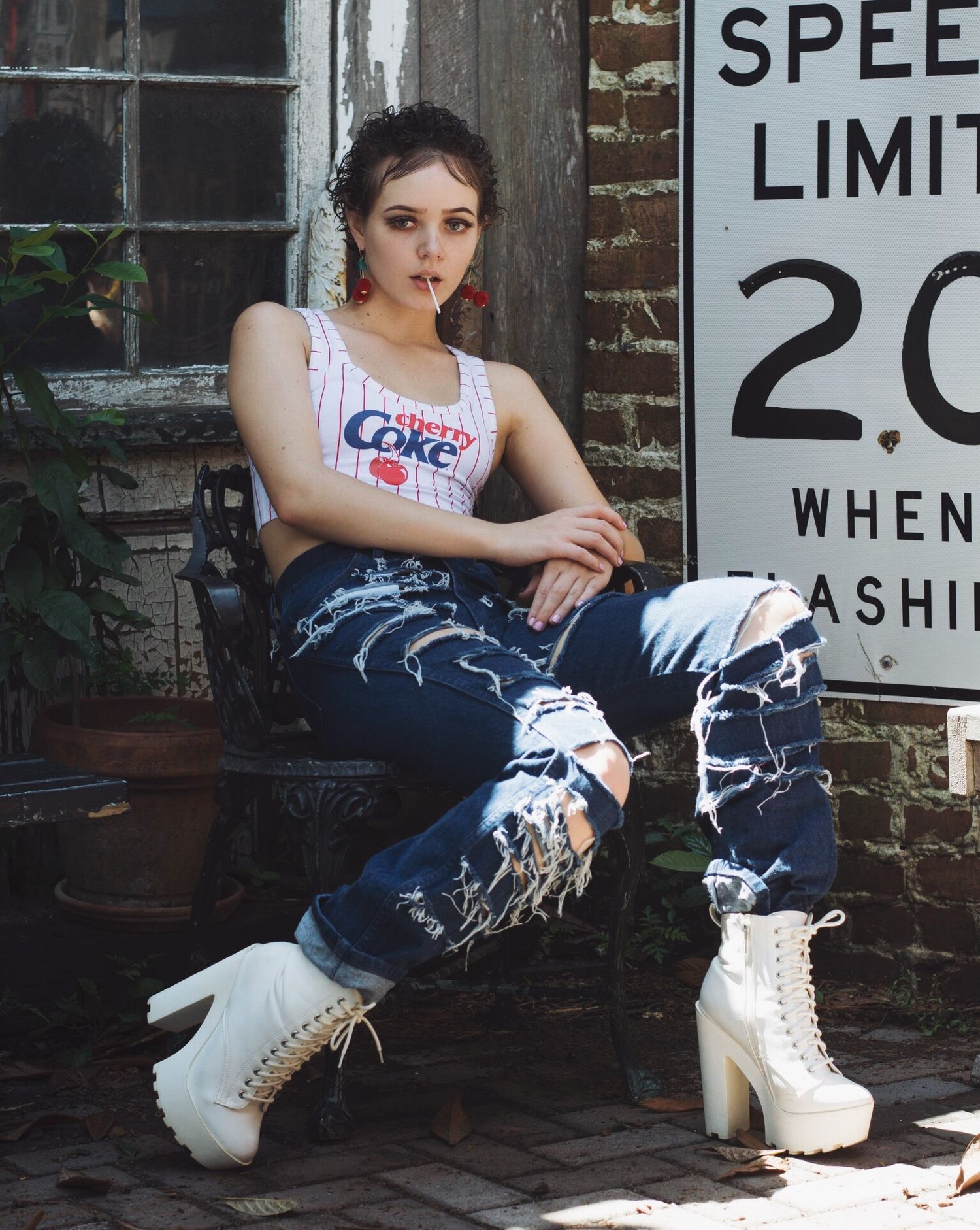 Urban fashion shoot with platform boots and distressed jeans near vintage street signs.