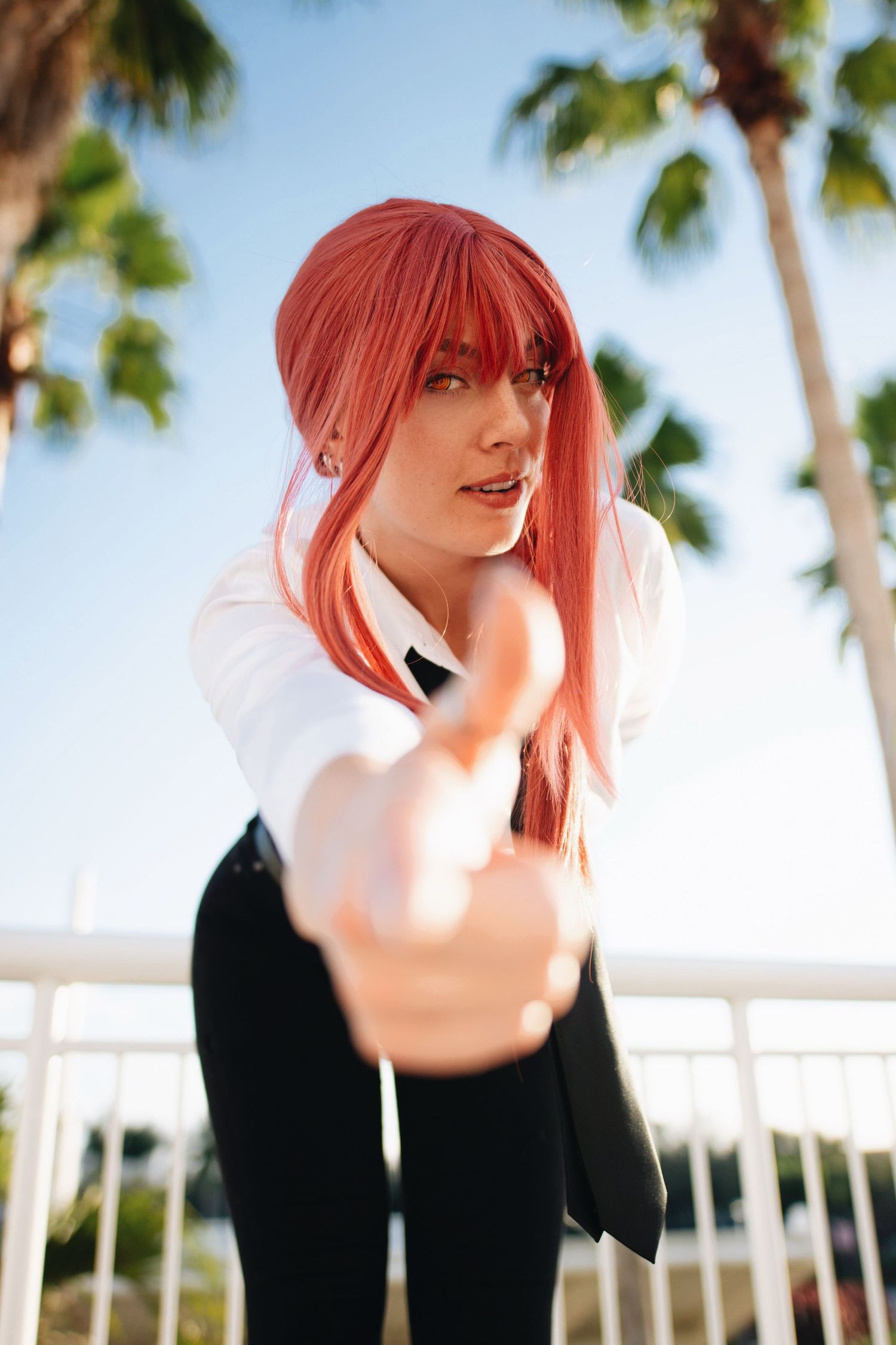 Outdoor cosplay photoshoot with red-haired character in casual black and white attire.