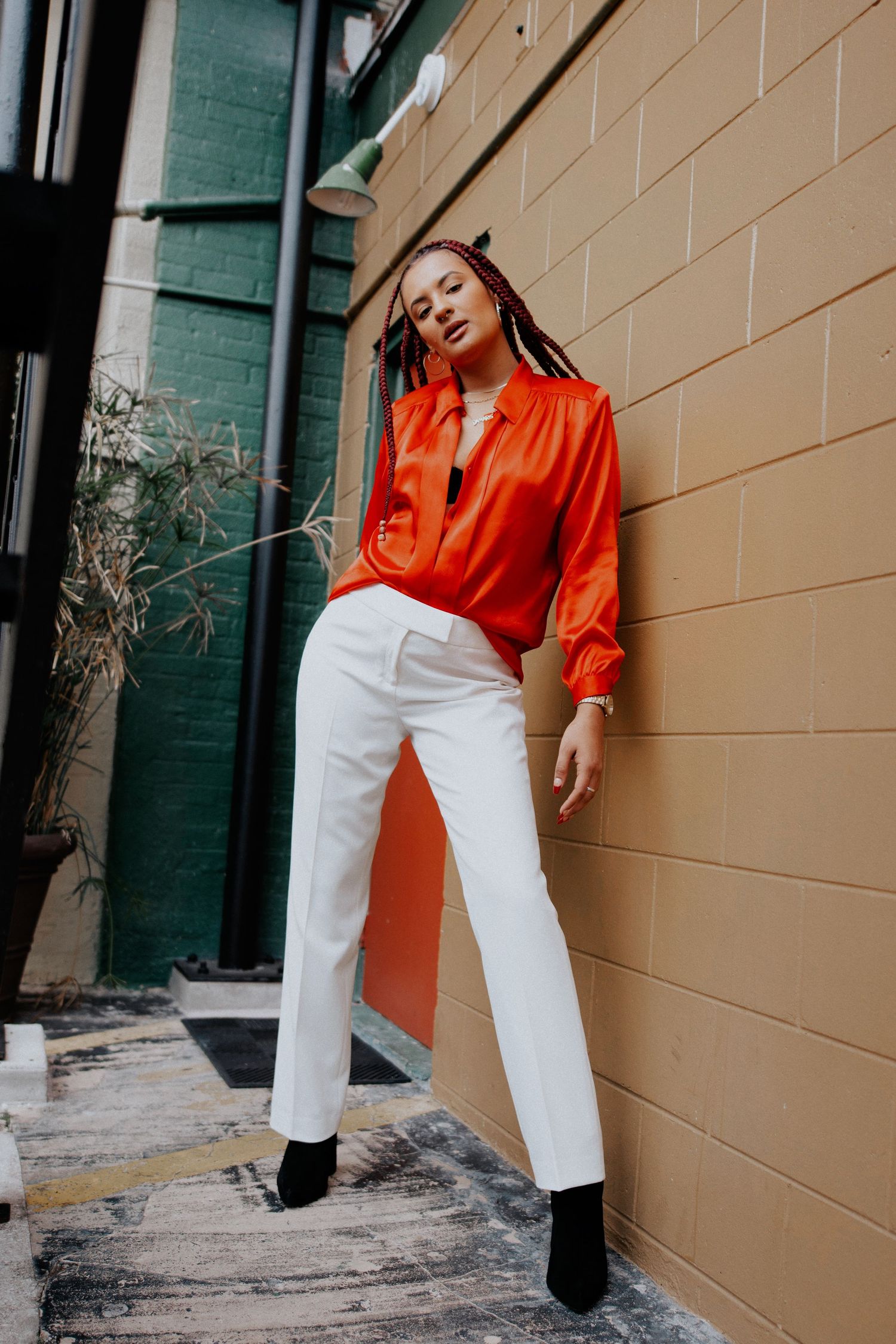 Fashion photography sequence showing orange and white outfit against beige wall.
