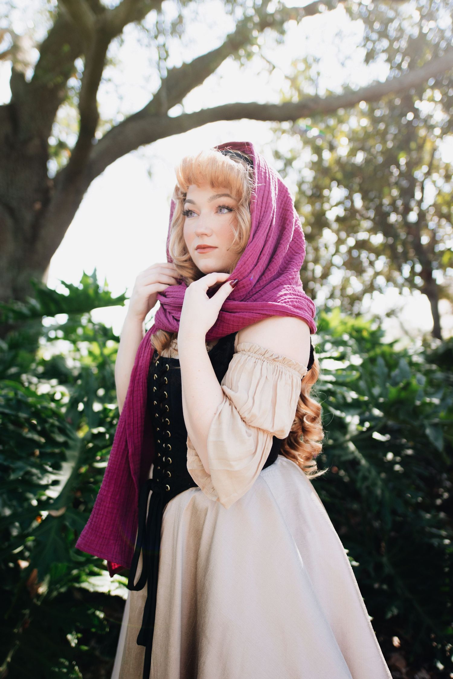 Expressive portrait series in period dress with burgundy scarf against foliage.