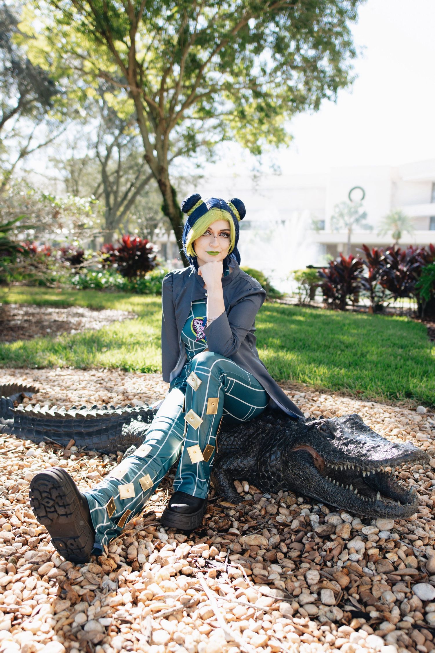 Modern streetwear cosplay with bear ear accessories sitting on decorative alligator sculpture.