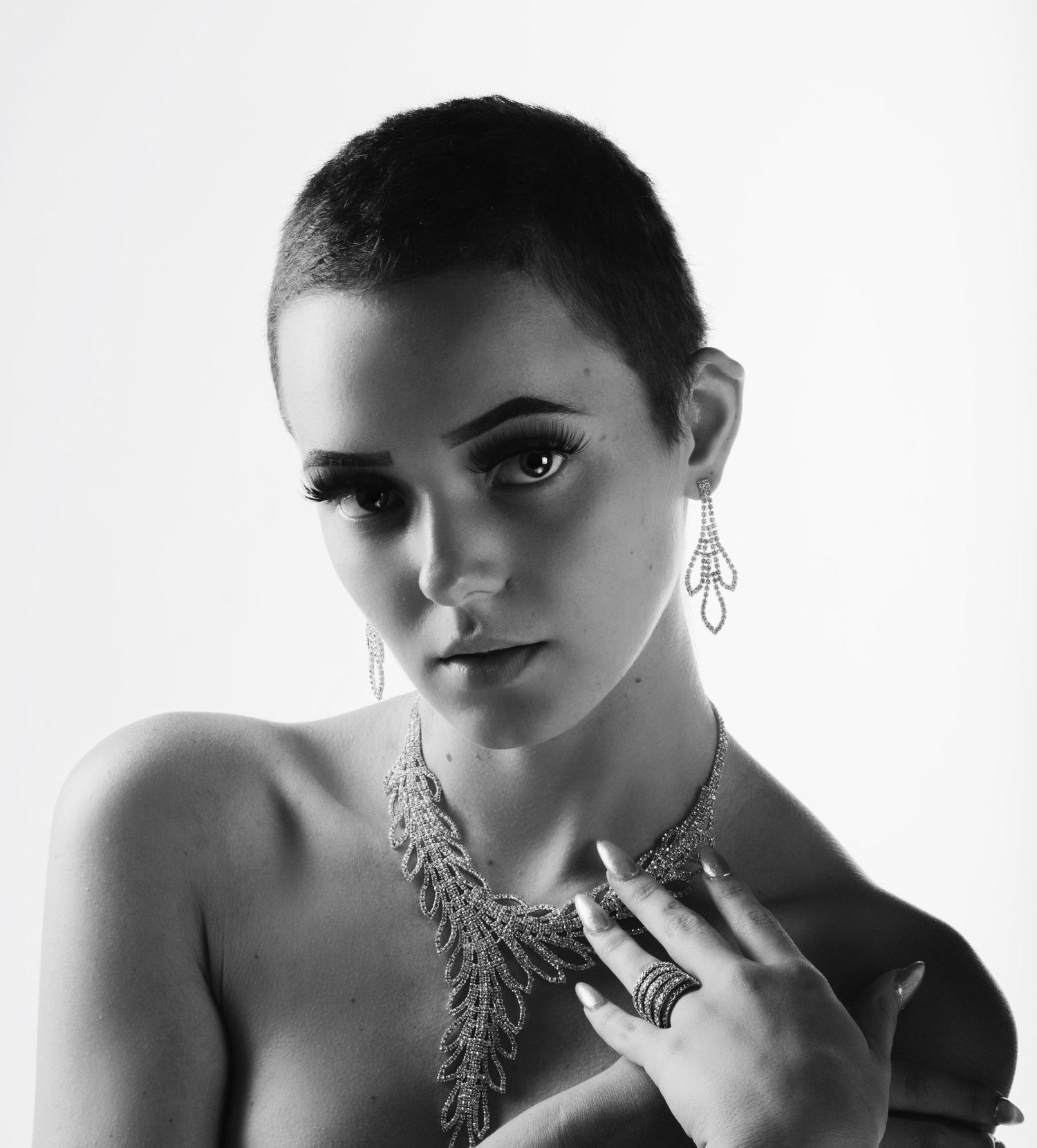 High contrast portrait series highlighting intricate silver statement necklaces against white background.