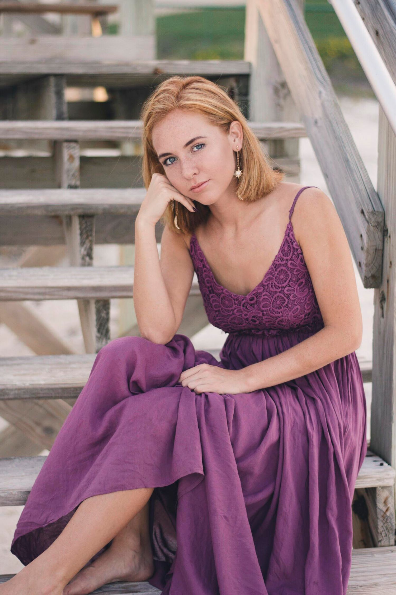 Purple dress portrait session on rustic wooden stairs with relaxed poses.