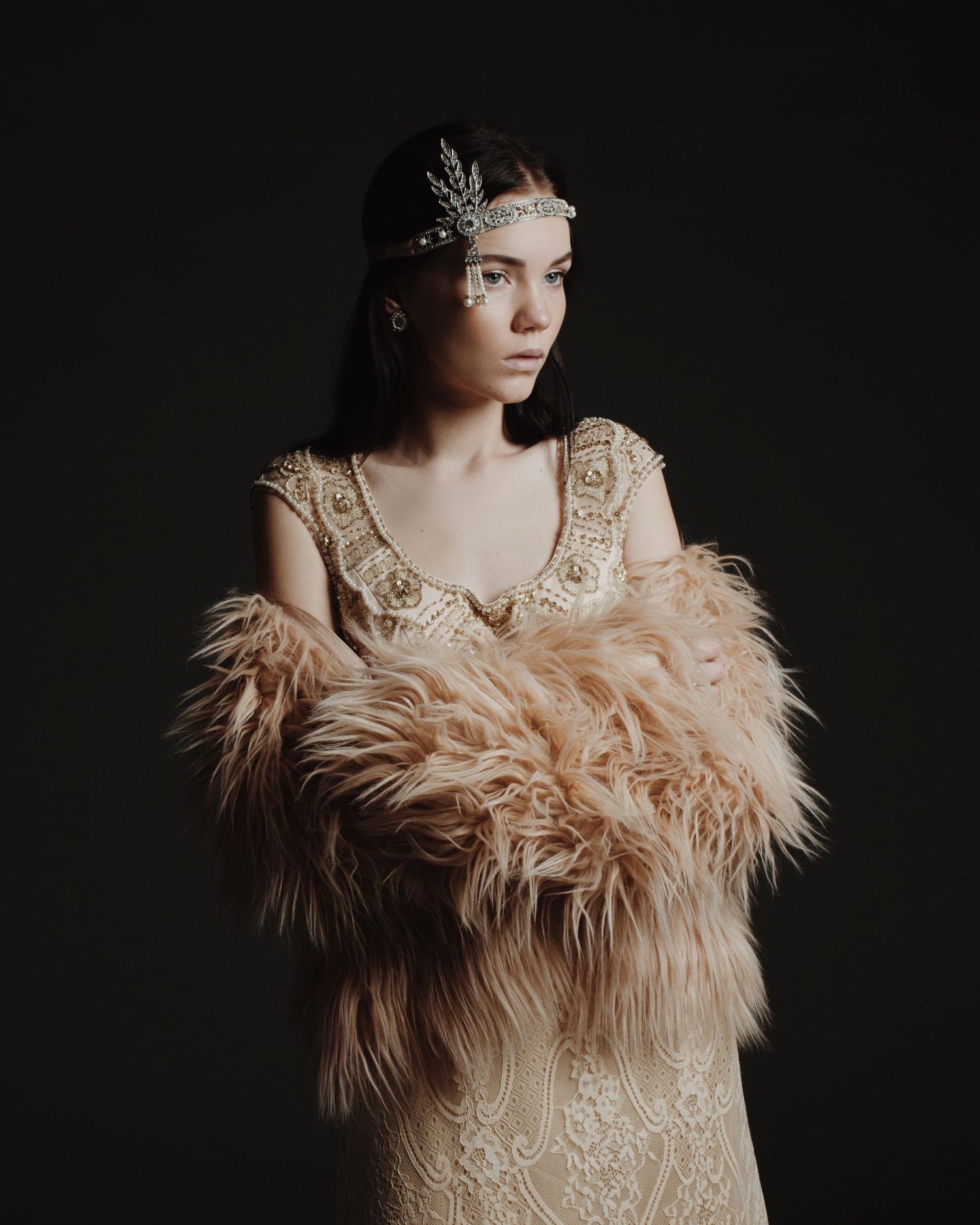 Elegant fashion portraits featuring feathered garments against dark background.