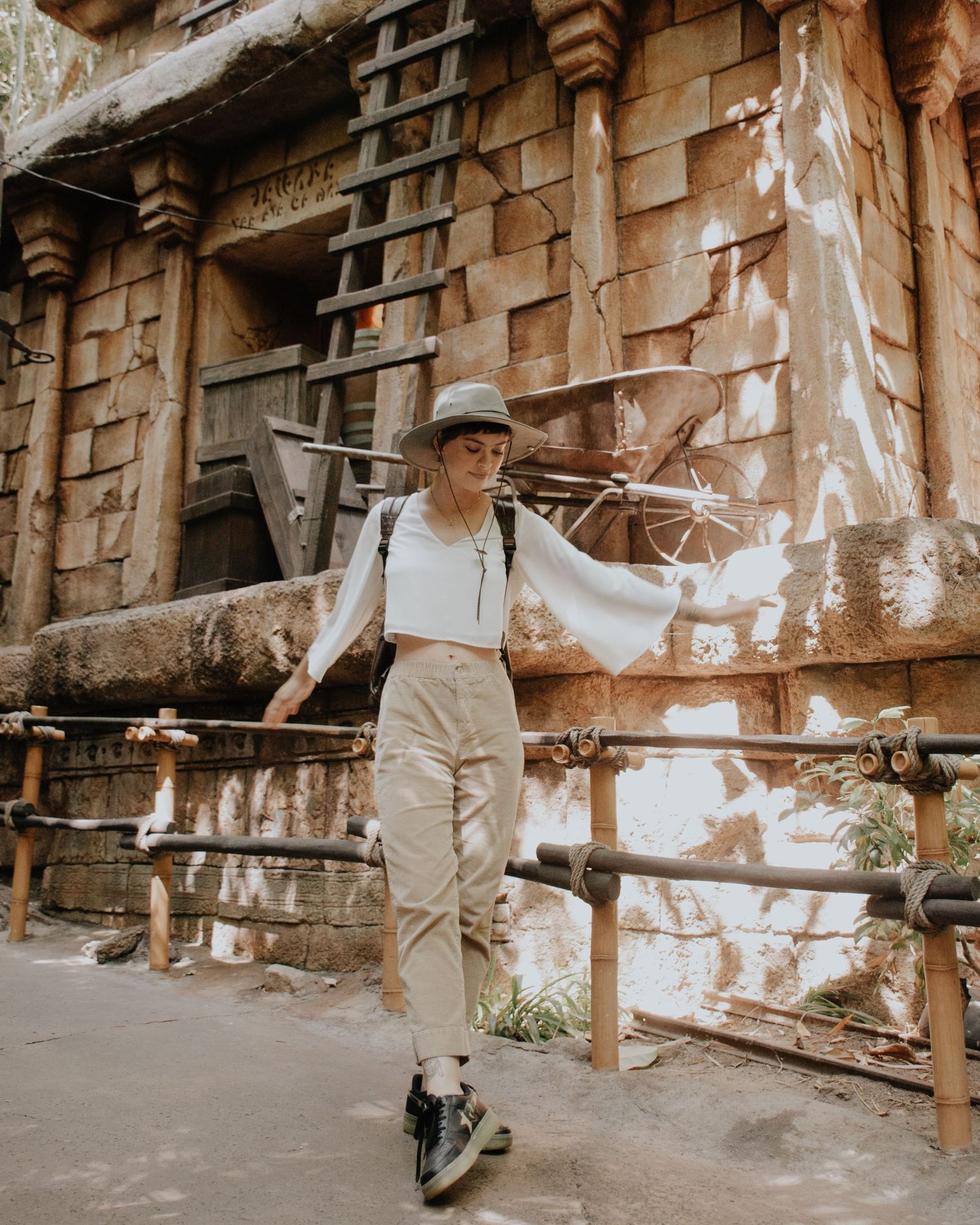 Person walking past weathered brick wall with peeling paint and exposed structure.