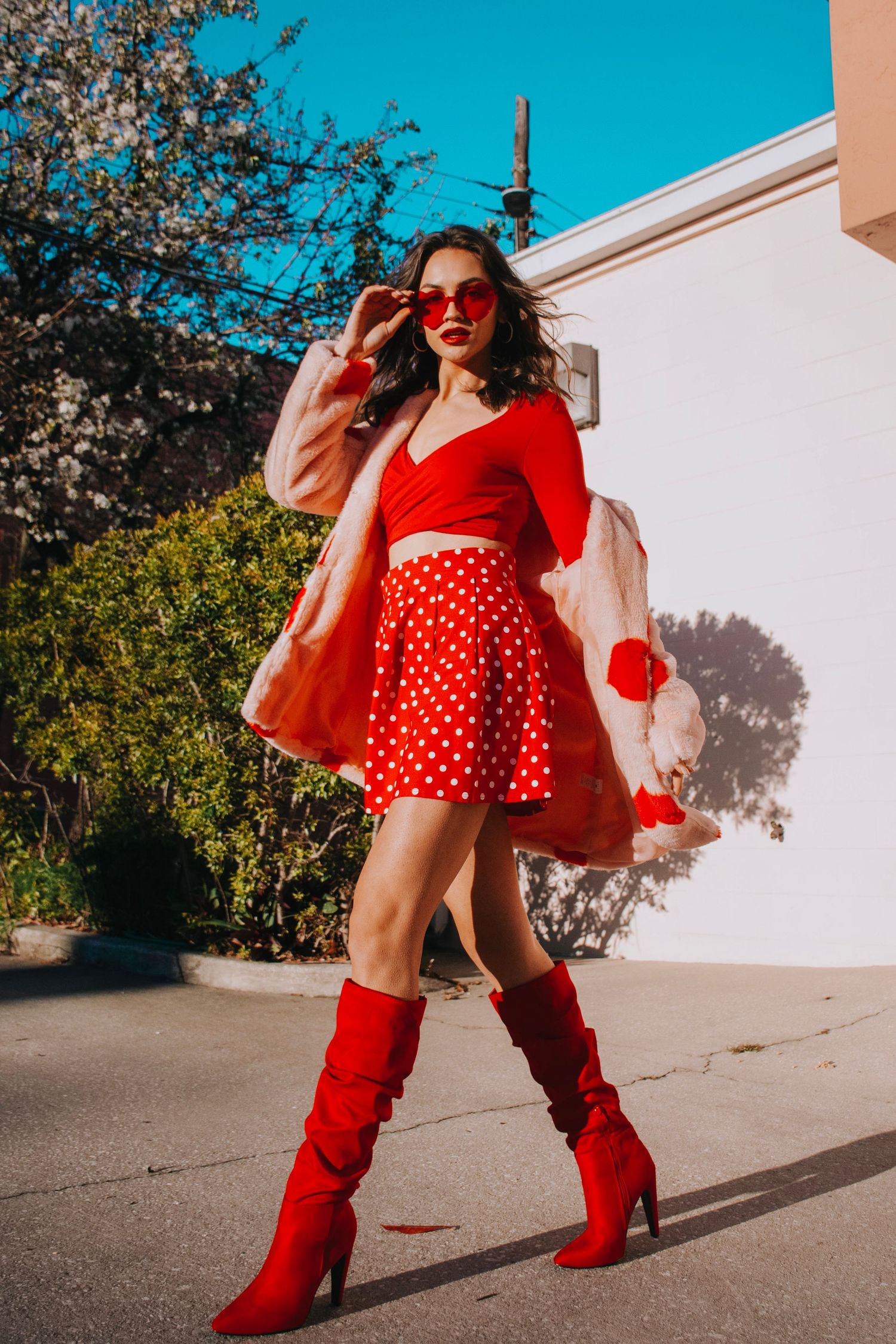 Fashion photos featuring red knee-high boots and polka dot dress against a bright blue sky backdrop.