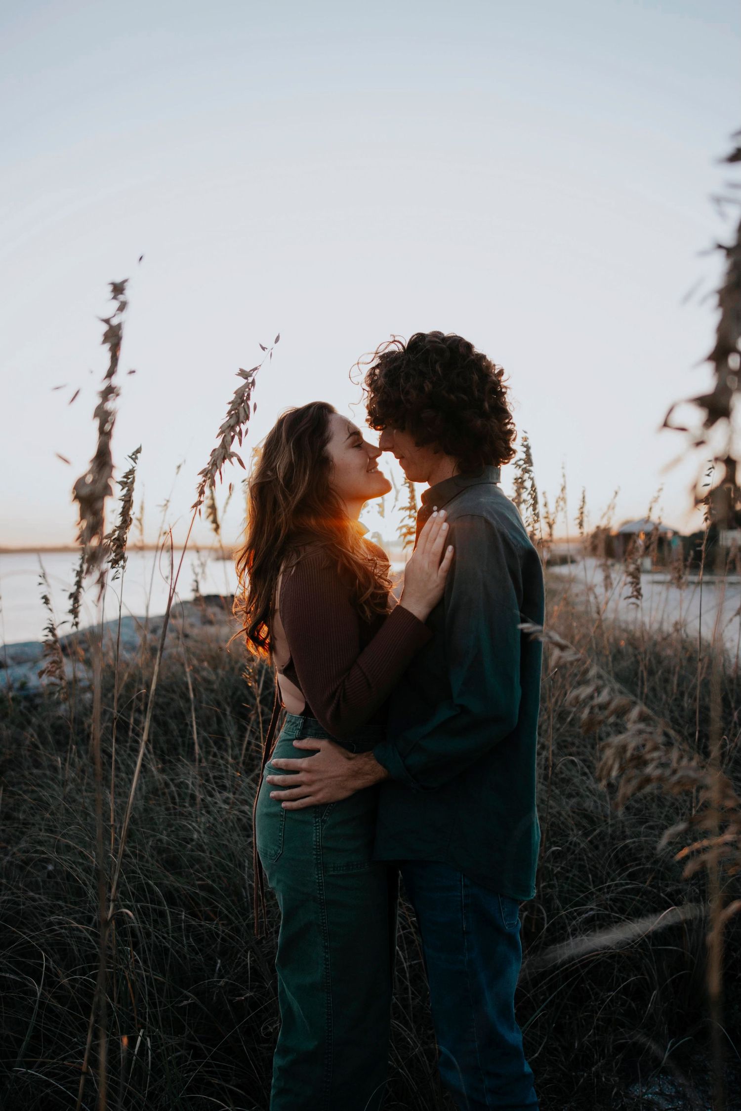 Romantic sunset photos among tall grass with natural golden hour lighting.
