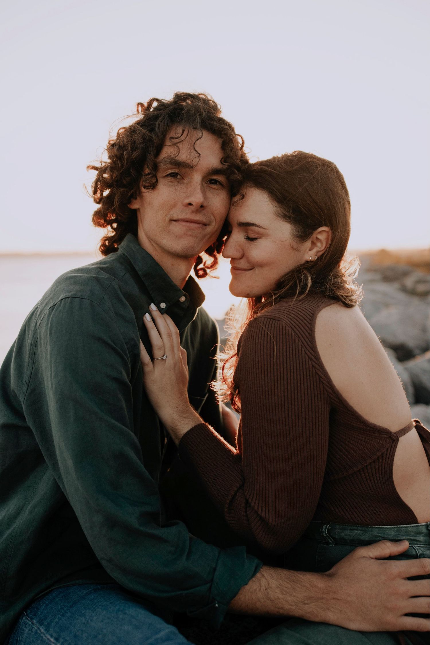 Intimate couple photoshoot at sunset with warm lighting and natural poses.