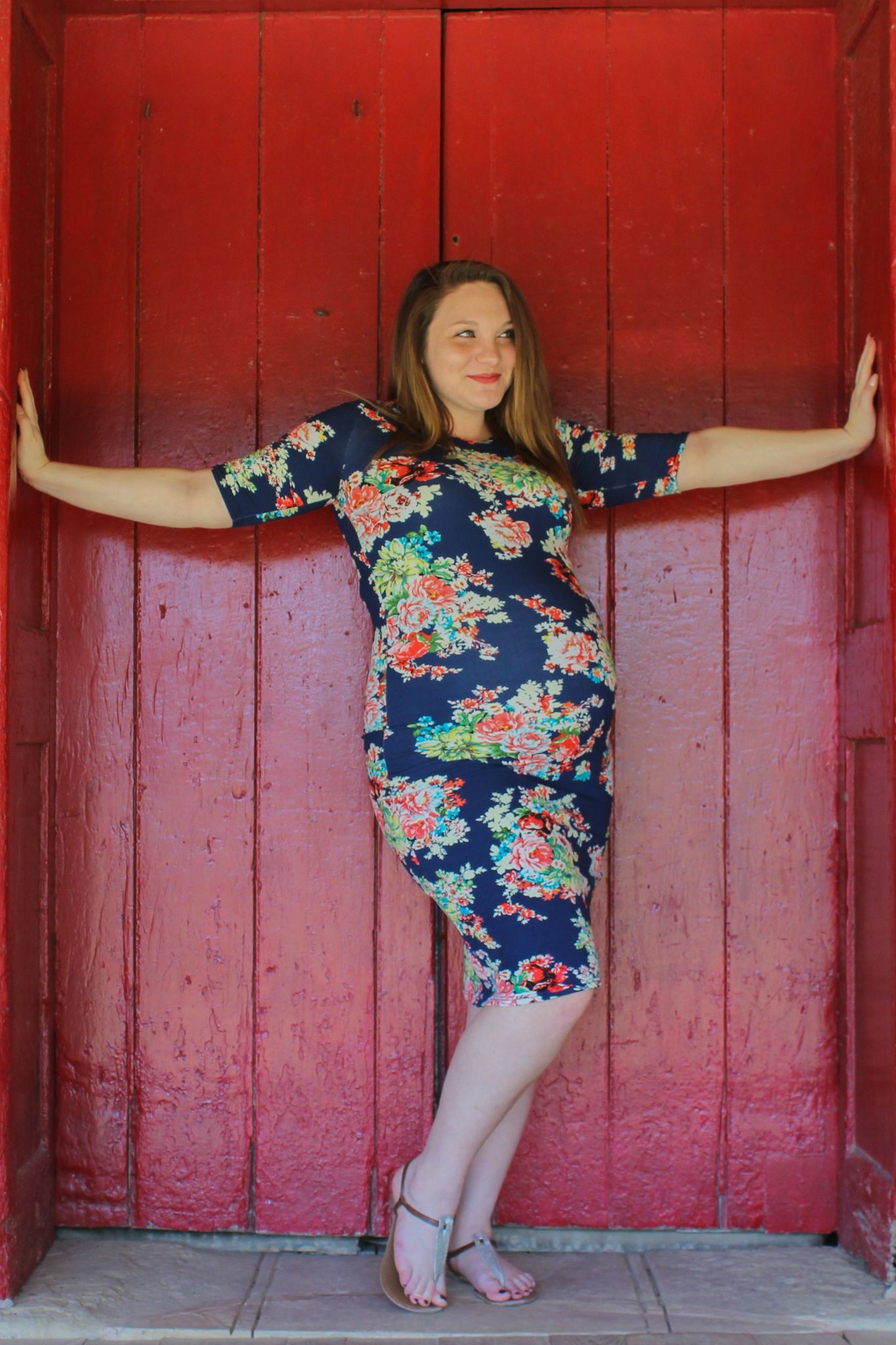 Person in floral dress poses creatively against red wooden wall in four sequential artistic shots.