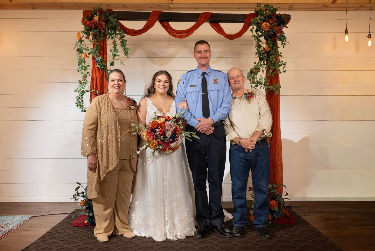 Wedding ceremony group photo with burgundy and tan color scheme.