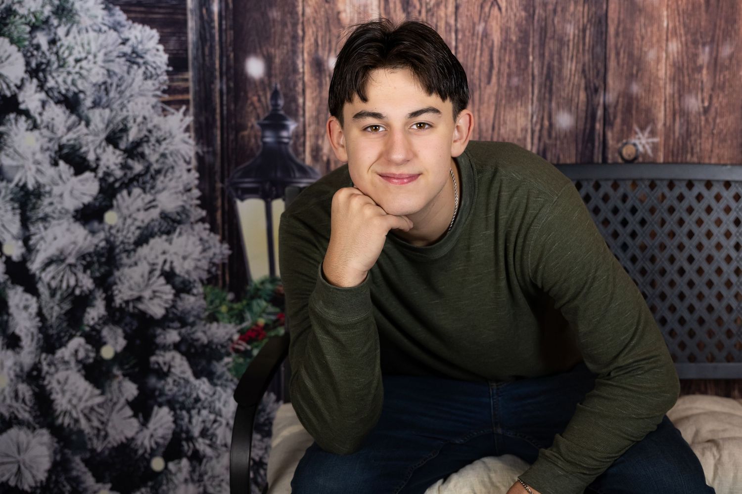 A person in a green sweater poses against a rustic wooden backdrop with snowy branches in multiple shots.