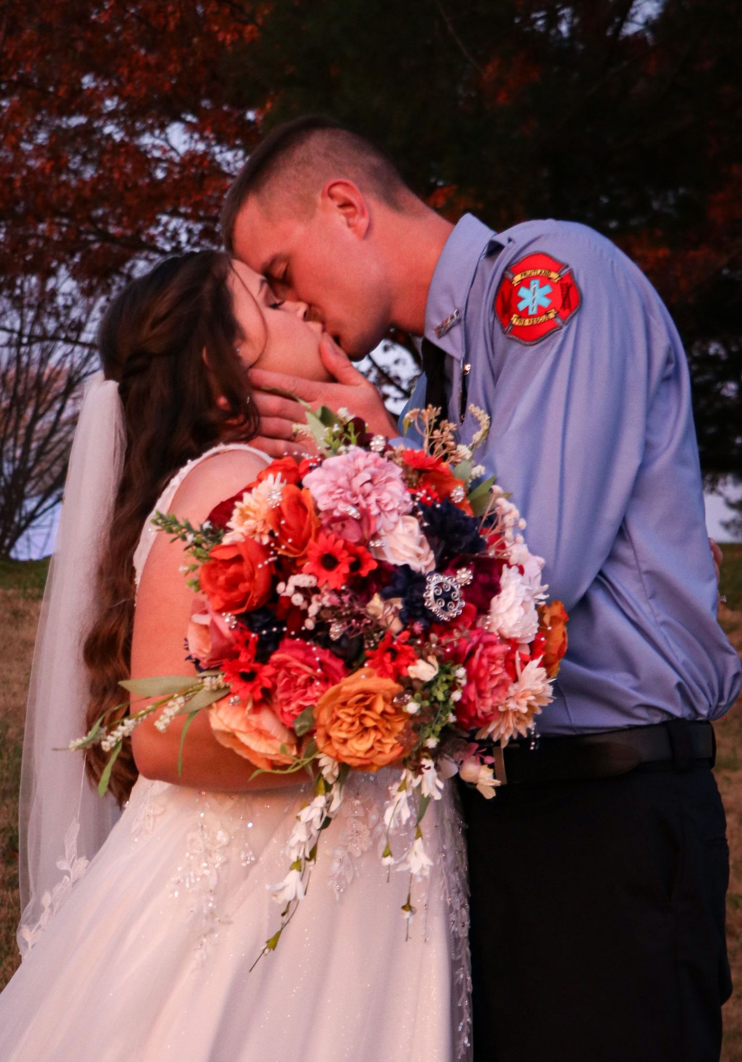 Romantic sunset wedding portrait with coral and navy bouquet.