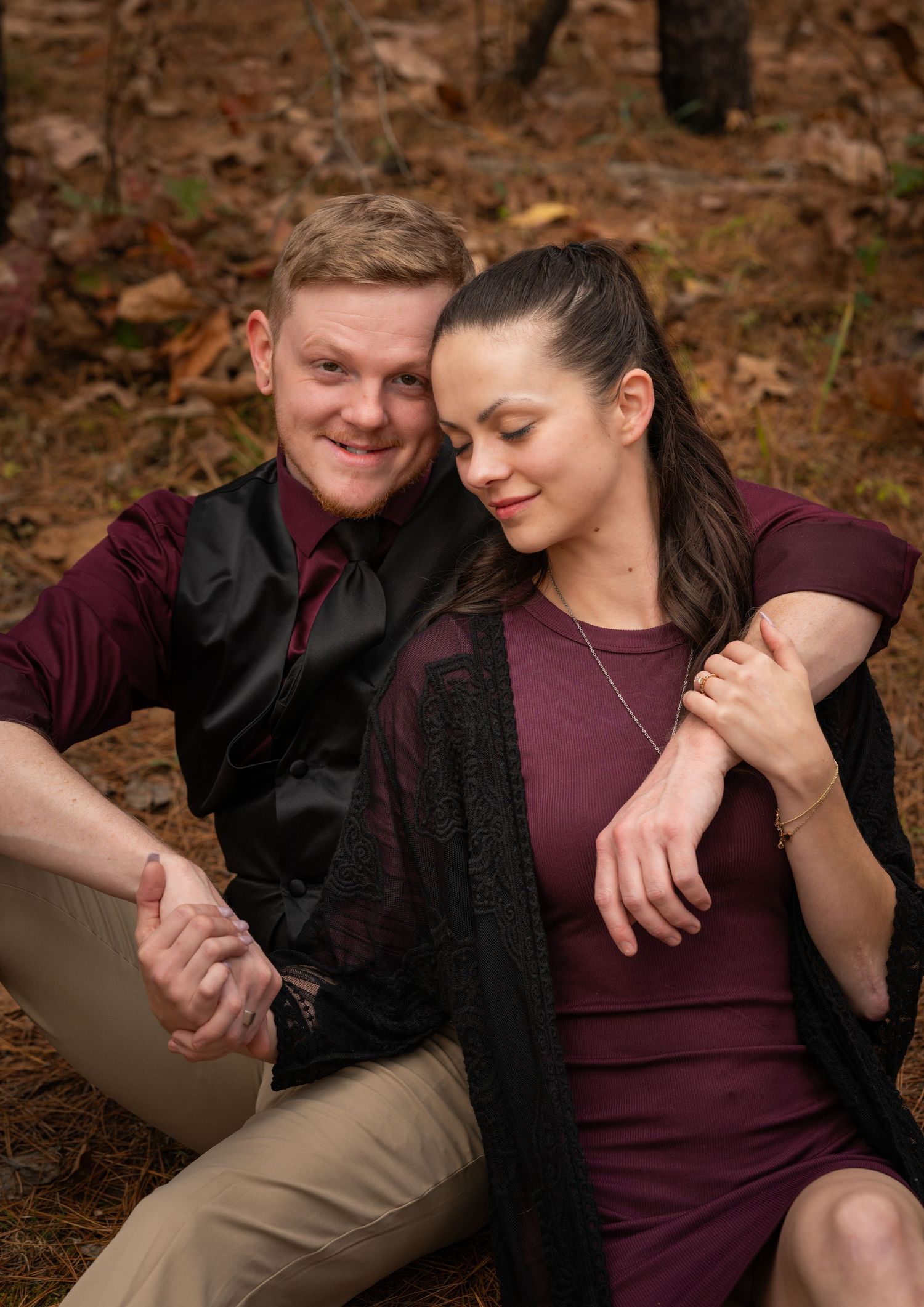 A couple shares tender moments in a romantic outdoor photo session among fallen autumn leaves.