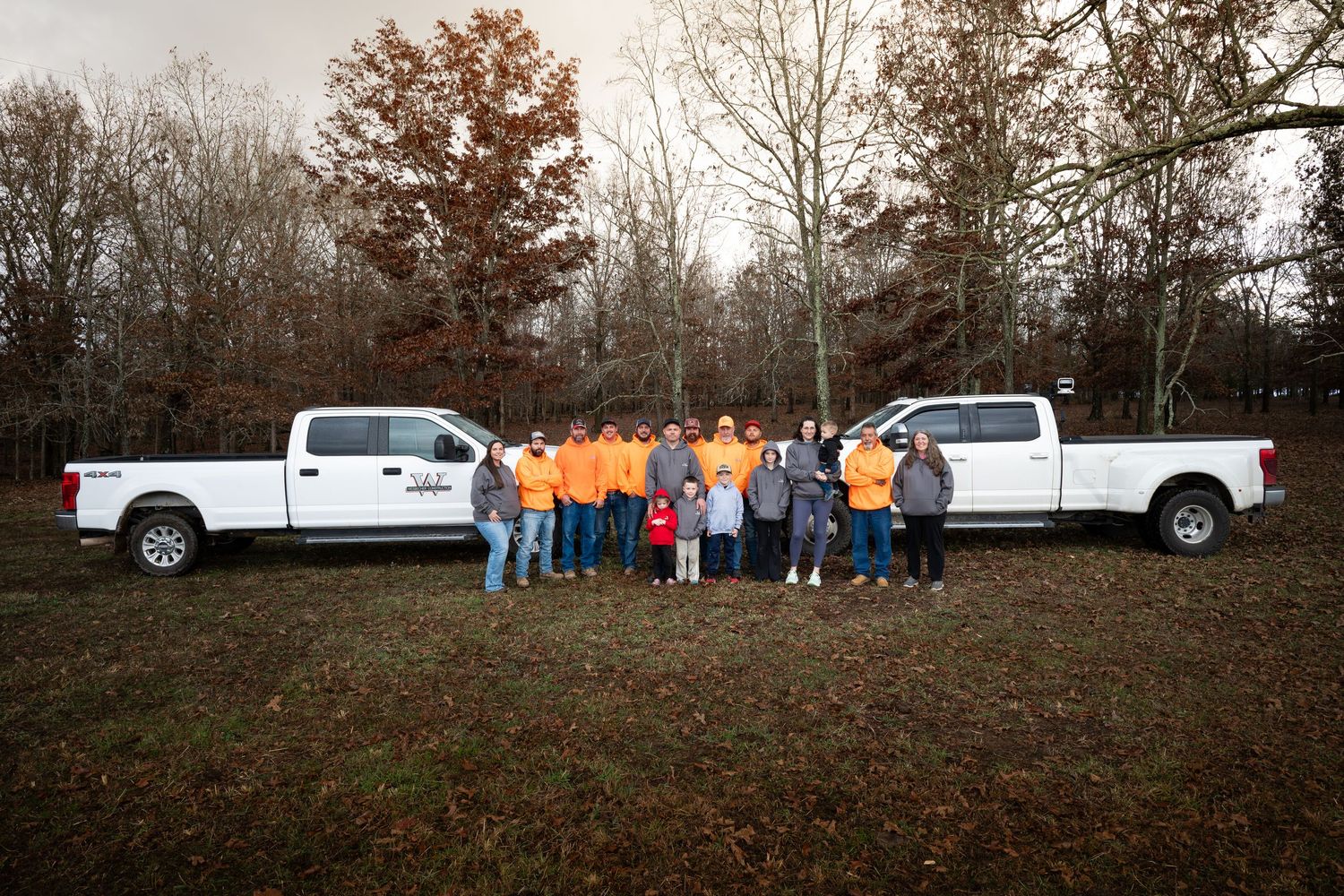 Panoramic group shot of workers and vehicles against autumn landscape.