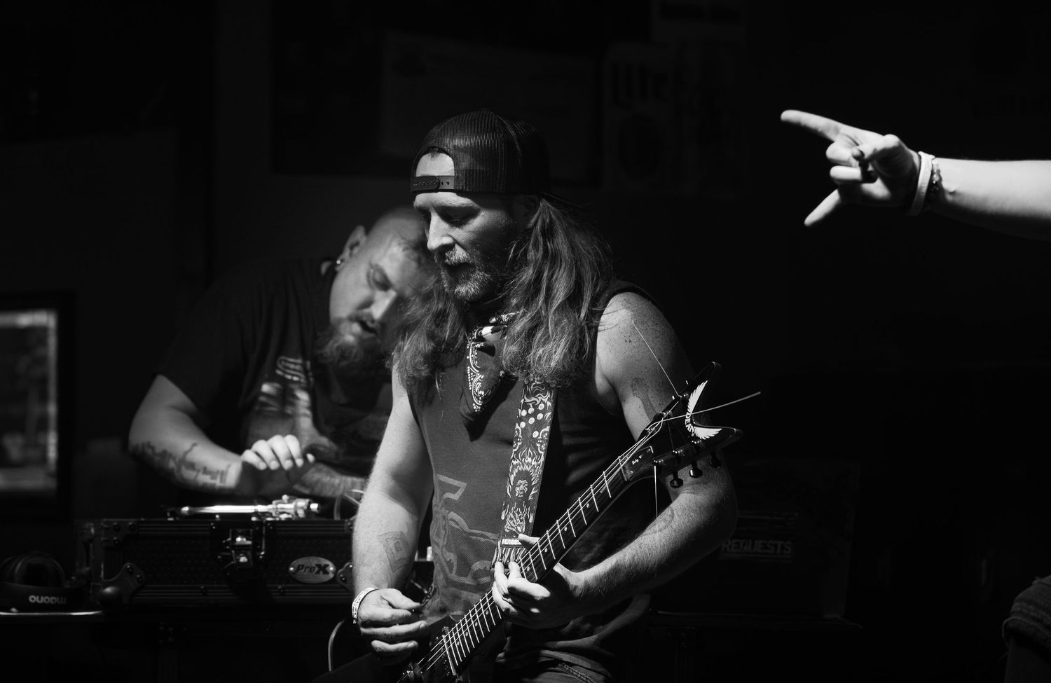 A dramatic black and white photo sequence shows a guitarist performing on stage with intense lighting effects.