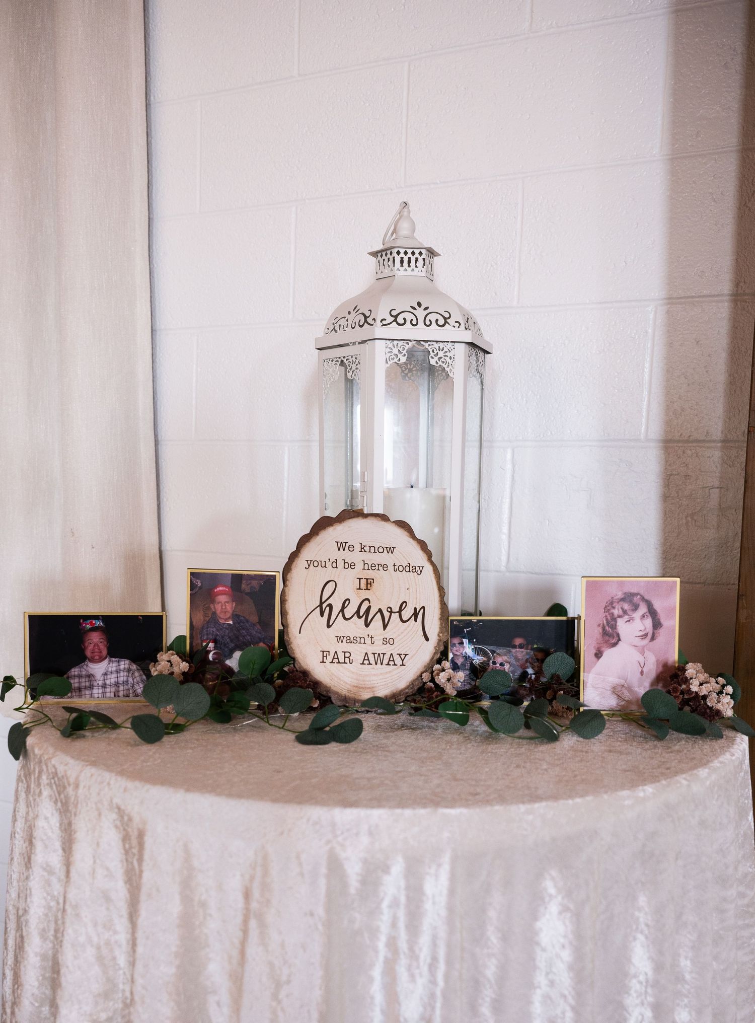 Wedding reception decor with white tablecloths and decorative signs displayed on an elegant table.