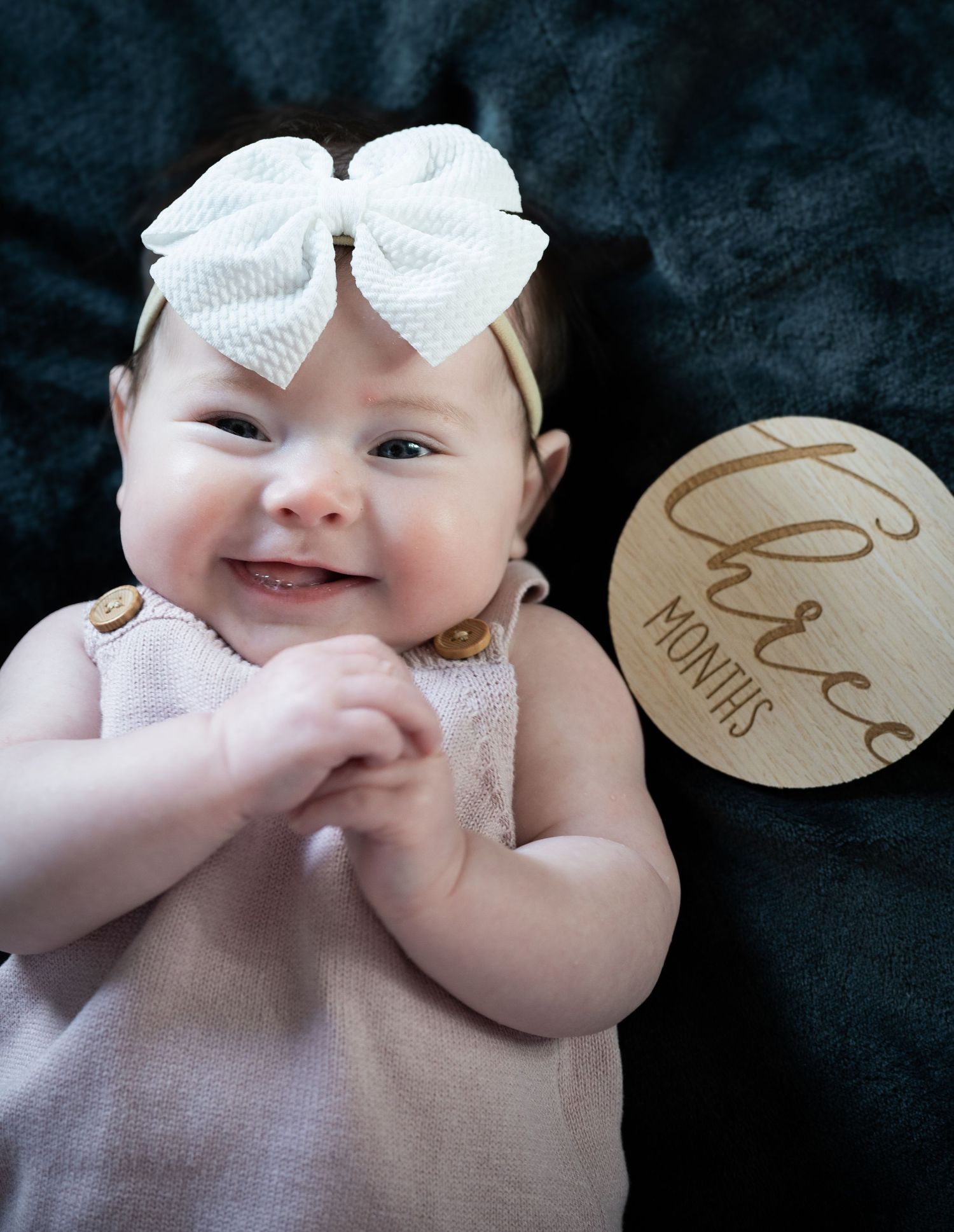 A series of black and white photographs showing a baby's playful expressions and hand gestures against a dark background.