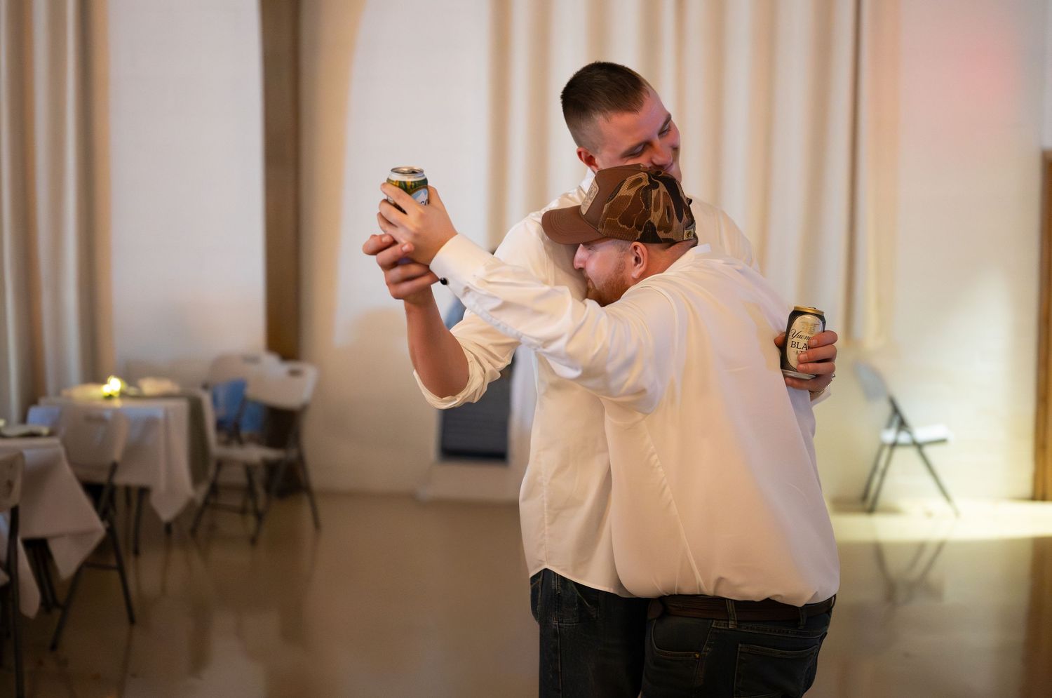 Wedding guests enjoying lively dance moves at indoor reception.