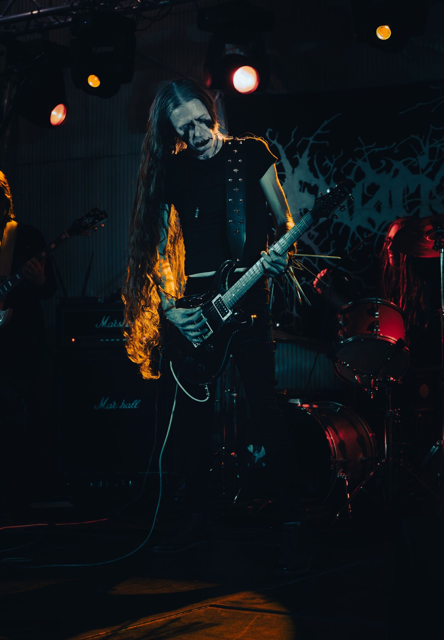 Performers on stage create a dramatic atmosphere with dynamic movements in dark lighting with orange and red accents.