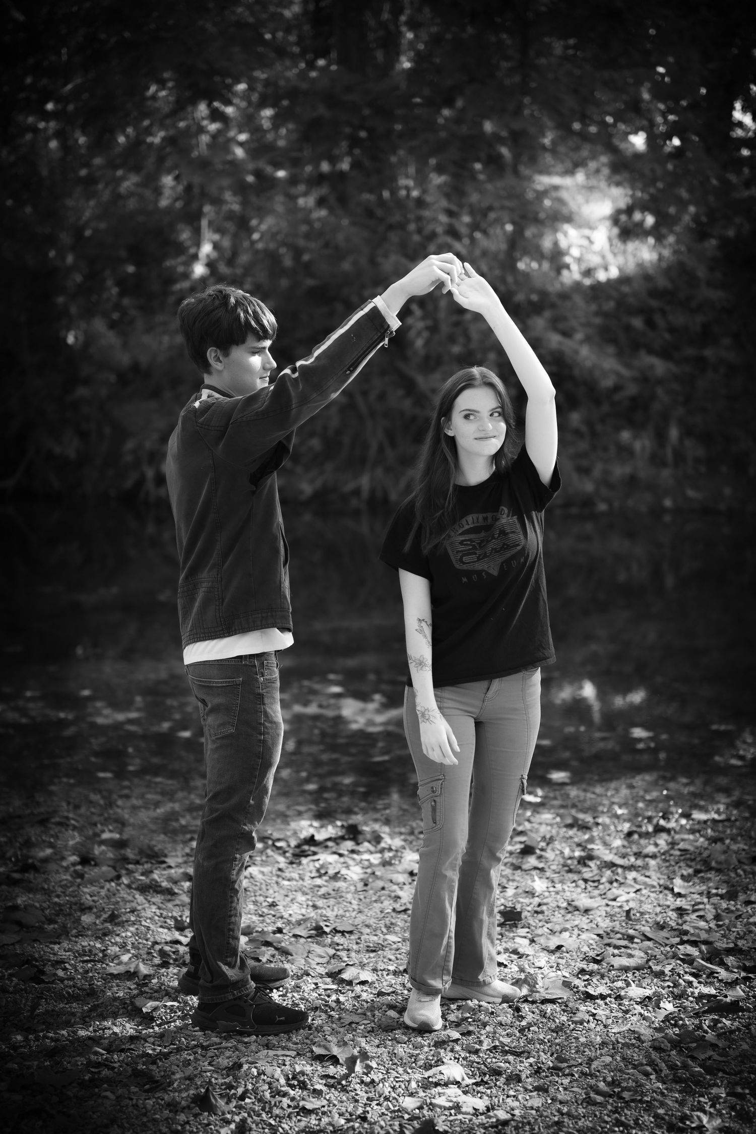 Black and white photo series showing two people dancing together in a playful sequence outdoors among fallen leaves.