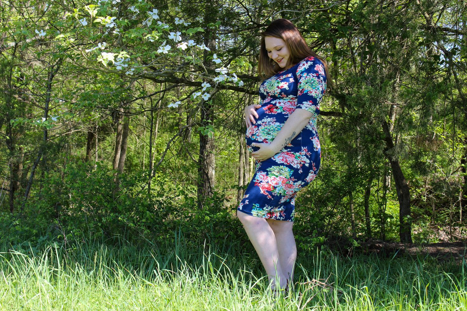 A floral dress stands out against a lush green forest backdrop on a sunny spring day.
