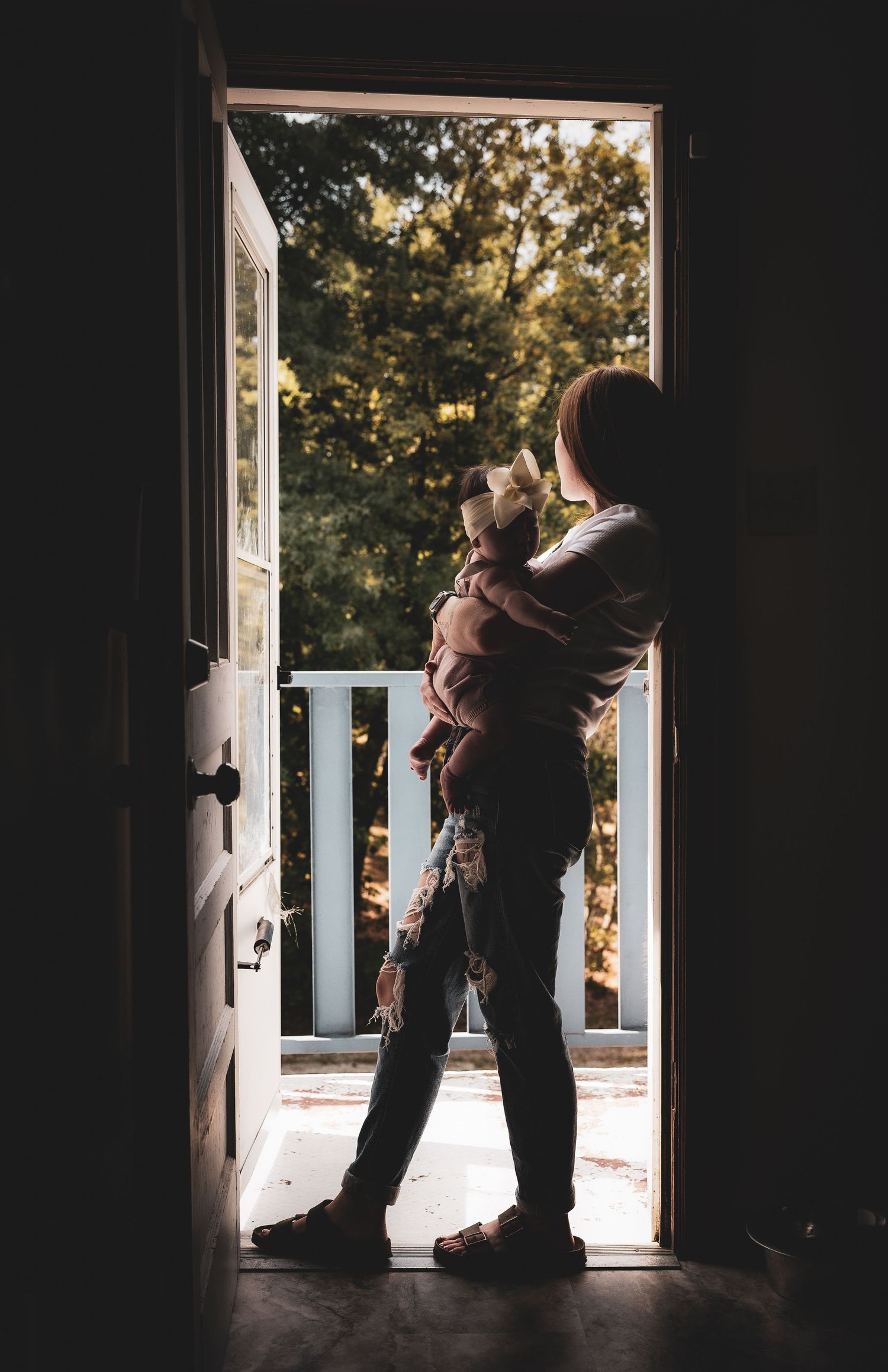 A silhouetted figure stands in a doorway against bright outdoor light in a sequence of five similar shots.