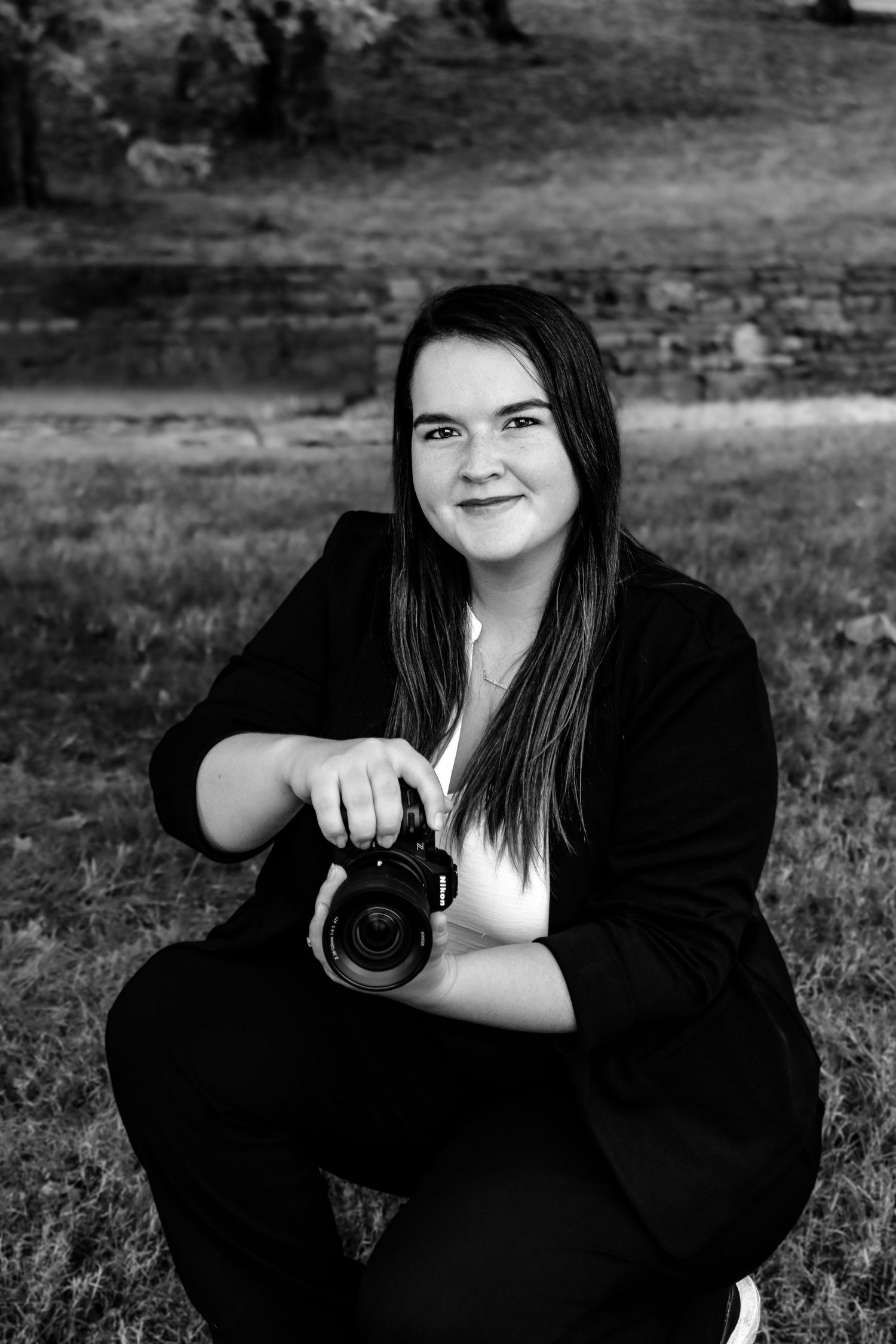 A series of black and white portraits showing someone in dark clothing holding a camera against an outdoor background.