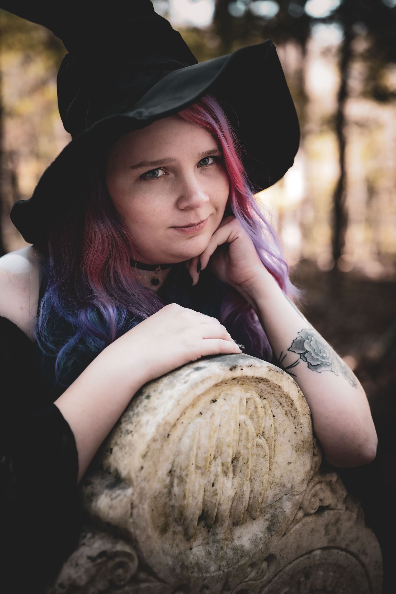 A person in a black hat rests their chin on a large beige mushroom in a moody forest setting.