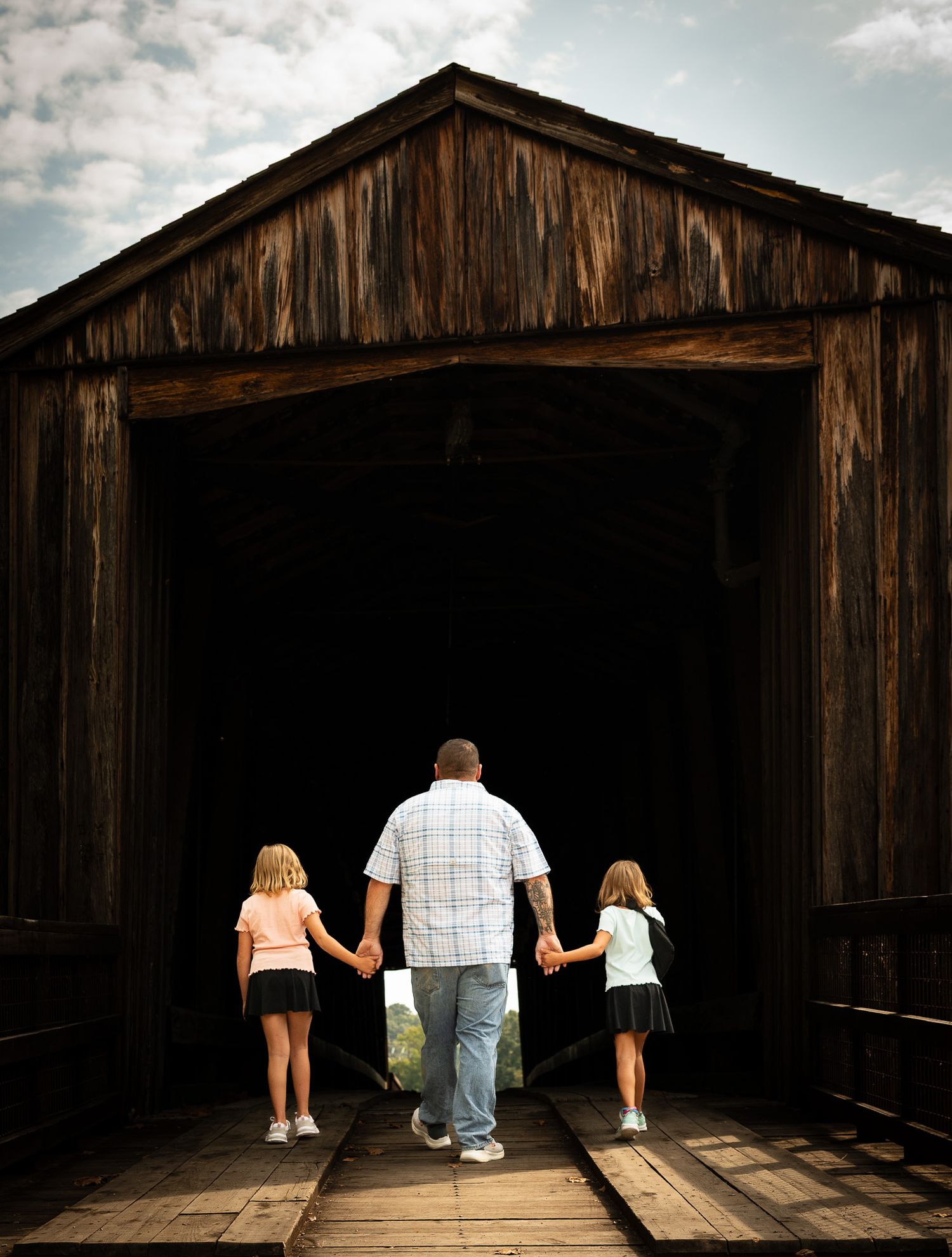A sequence of photos showing people walking into a dark wooden barn structure, creating a silhouette effect against the light.