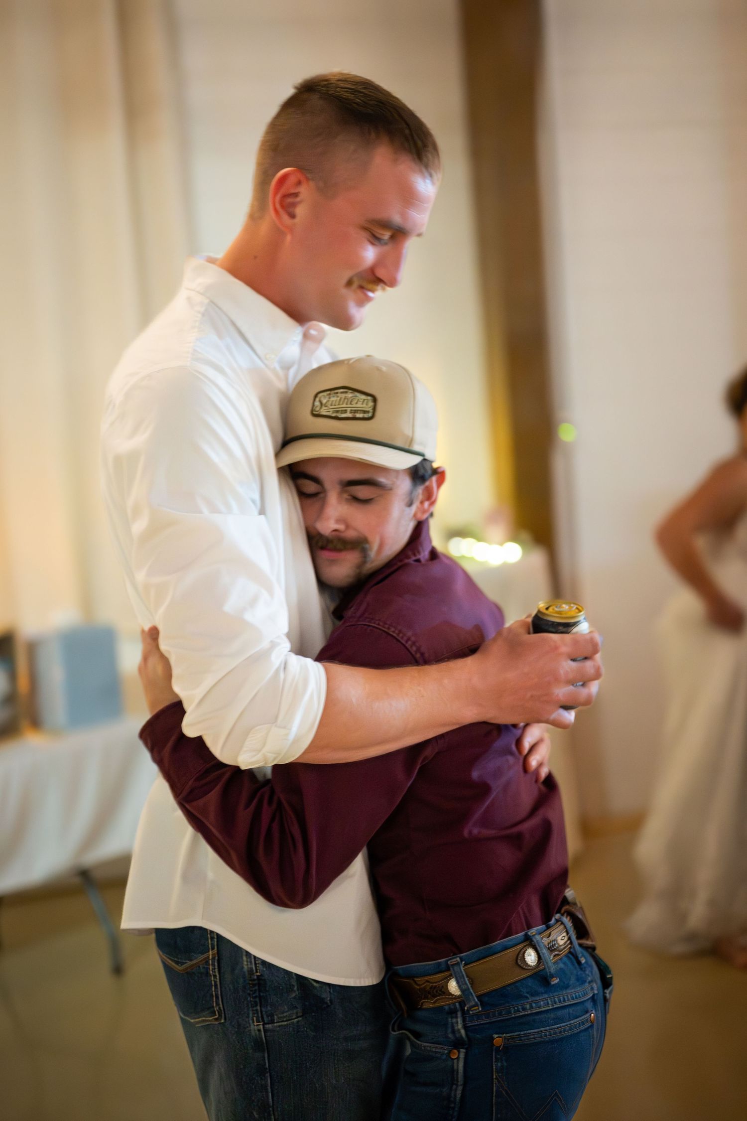 Two wedding guests sharing a fun dance moment at indoor reception.