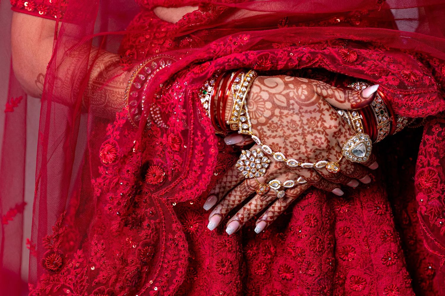 Close-up of intricate bridal mehndi and jewelry over red lehenga during Indian wedding at Hyatt Ziva Puerto Vallarta, by José Carrillo Photo