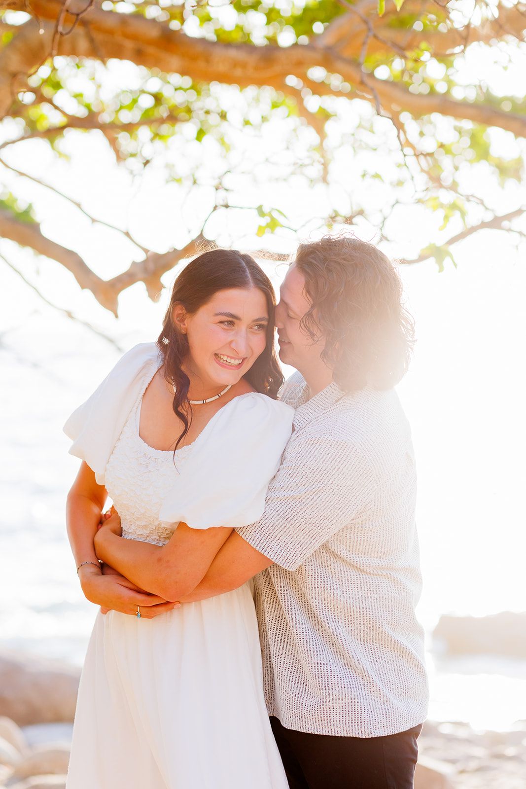 Couple sharing a romantic moment during their engagement session by the ocean in Puerto Vallarta, captured by José Carrillo Photography.