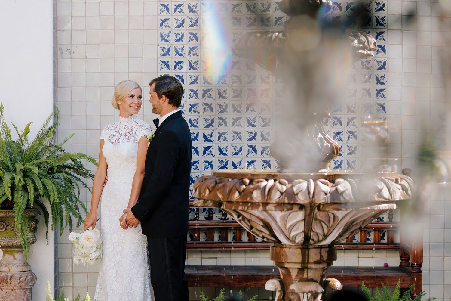 Bride and groom share a romantic moment beside a tiled fountain in Puerto Vallarta, captured with elegance by José Carrillo Photography.
