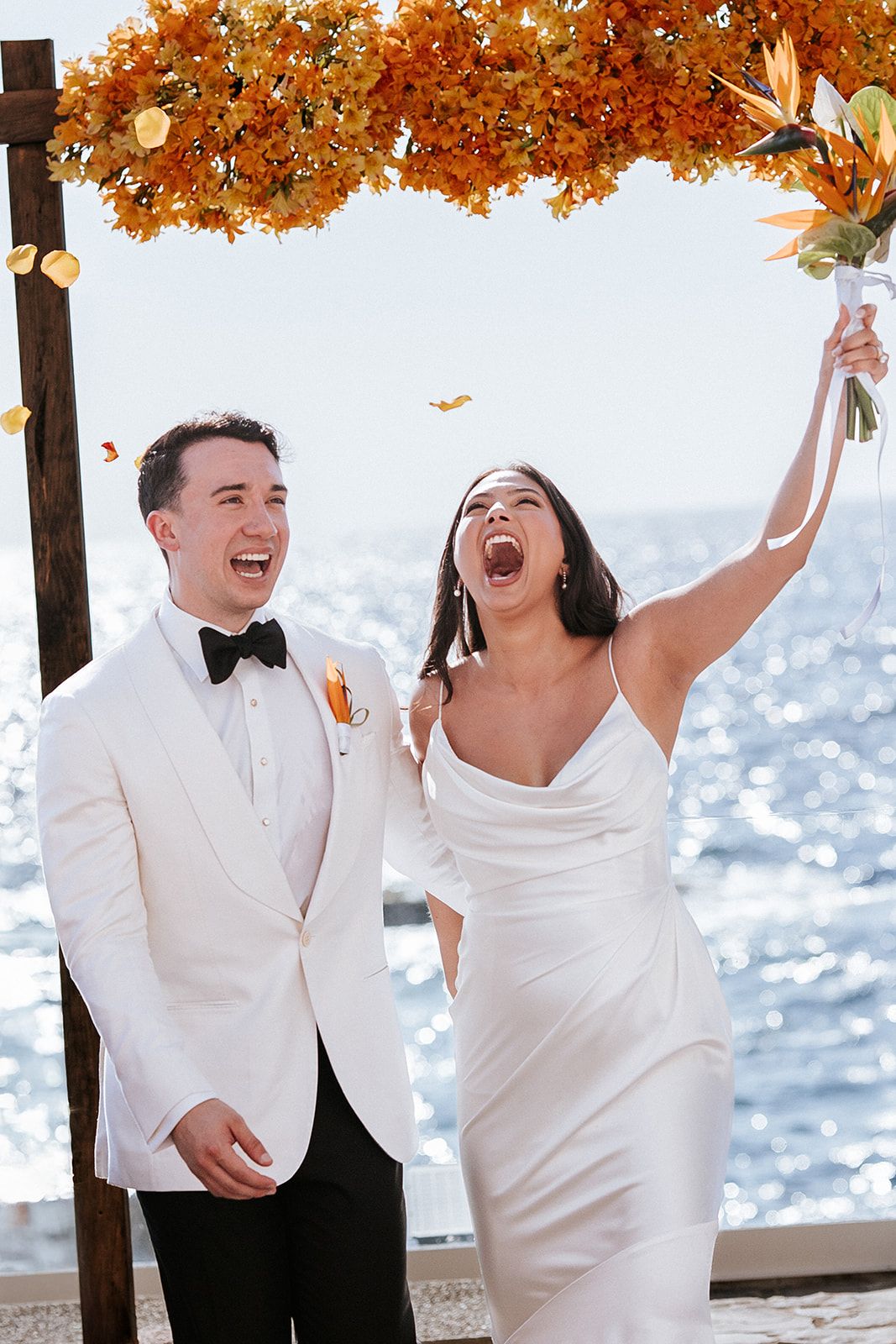 Bride and groom celebrating their oceanfront wedding in Puerto Vallarta under golden floral decor, documented by José Carrillo Photography.