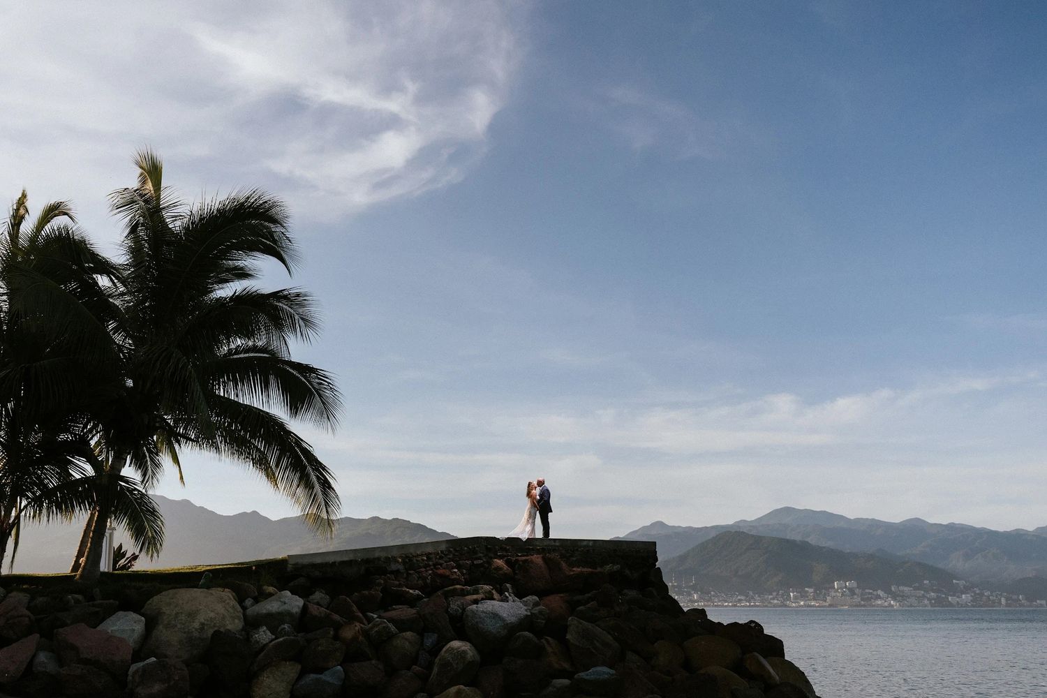 Newlywed couple embracing by the ocean at sunset in Puerto Vallarta, captured on the coast by José Carrillo Photography.