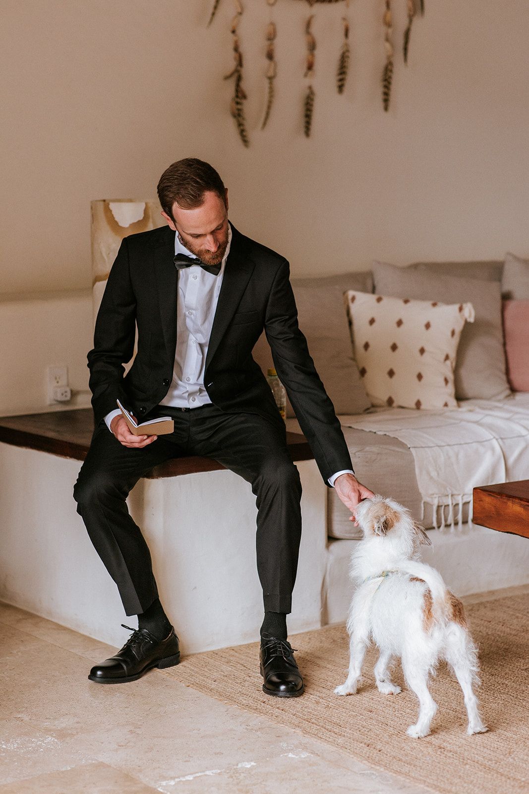 Groom shares a calm moment with his small dog while getting ready before the wedding in Puerto Vallarta, by José Carrillo Photography.