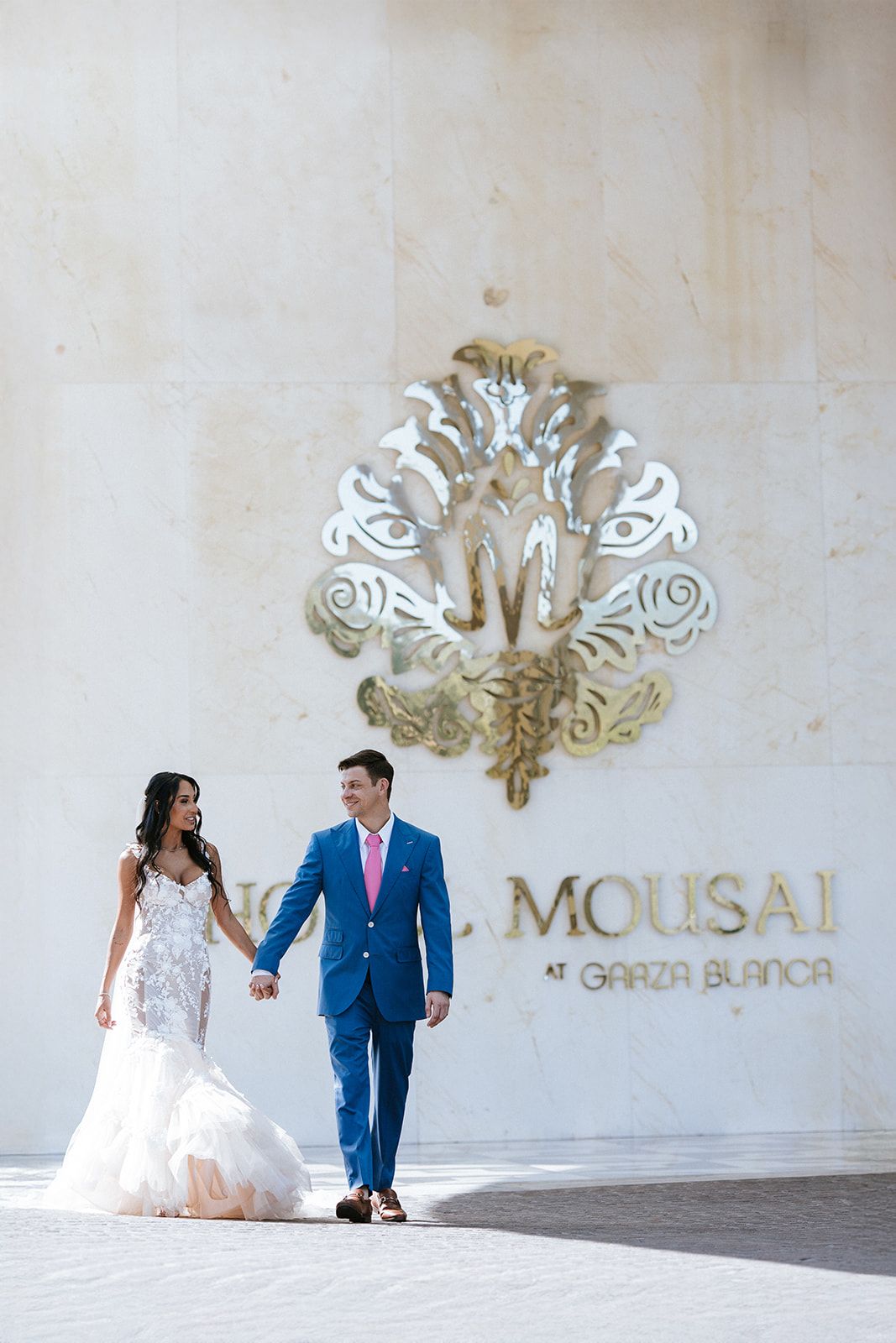 Bride and groom walk hand in hand at Mousai Garza Blanca in Puerto Vallarta, captured by destination wedding photographer José Carrillo